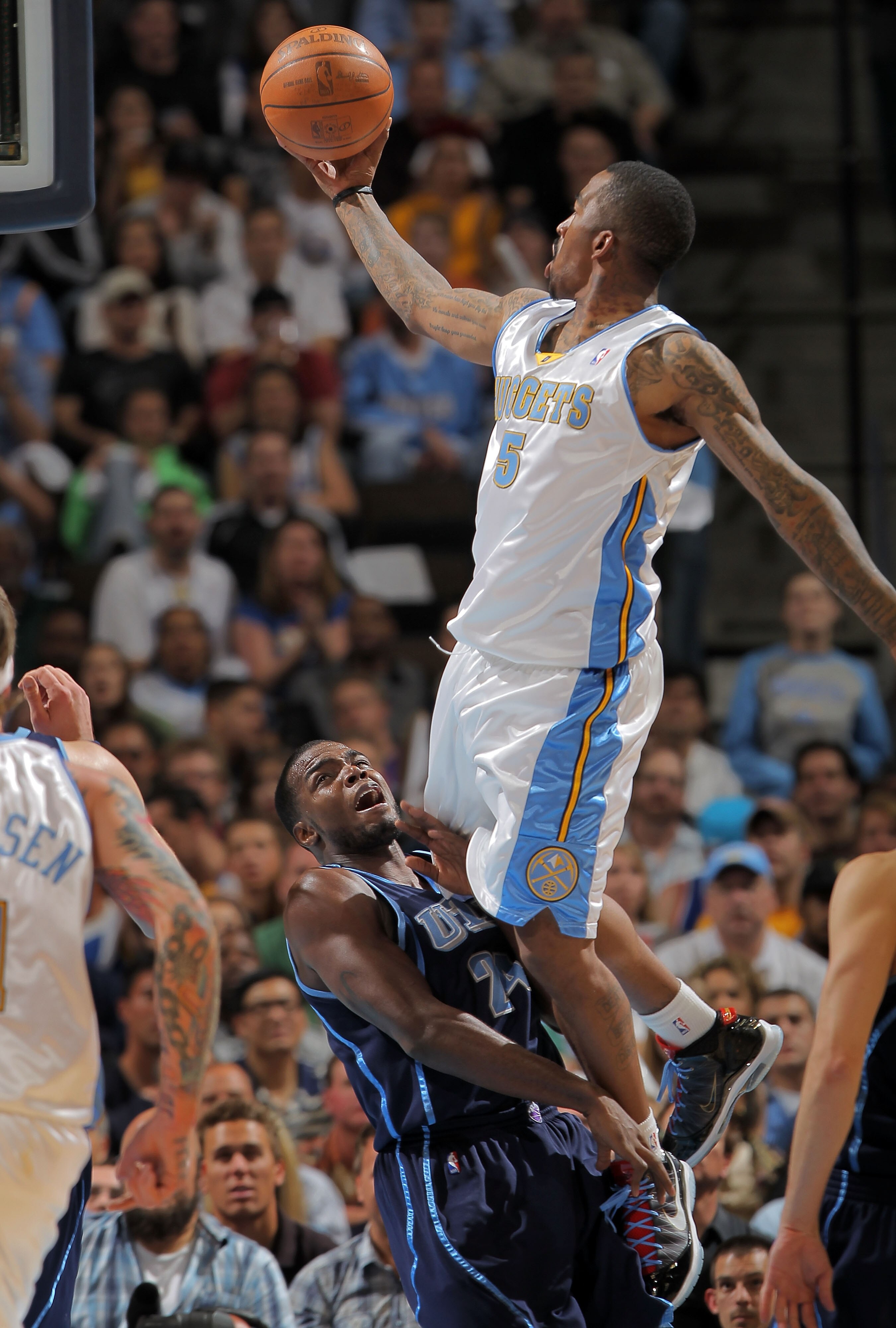 DENVER - APRIL 28:  J. R. Smith #5 of the Denver Nuggets is called for an offensive foul as he goes up for a shot over Paul Millsap #24 of the Utah Jazz in Game Five of the Western Conference Quarterfinals of the 2010 NBA Playoffs at the Pepsi Center on A