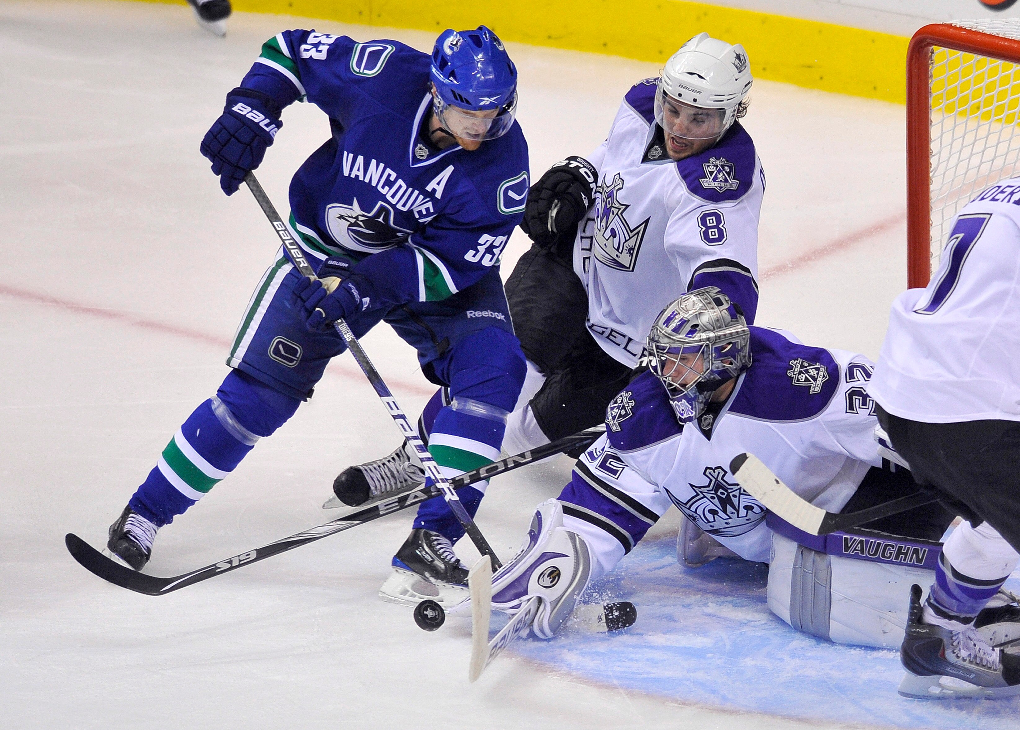 VANCOUVER, CANADA - APRIL 15: Henrik Sedin #33 of the Vancouver Canucks tries to slip a backhand shot past goalie Jonathan Quick #32 of the Los Angeles Kings after getting past Drew Doughty #8 of the Kings during the overtime period in Game One of the Wes