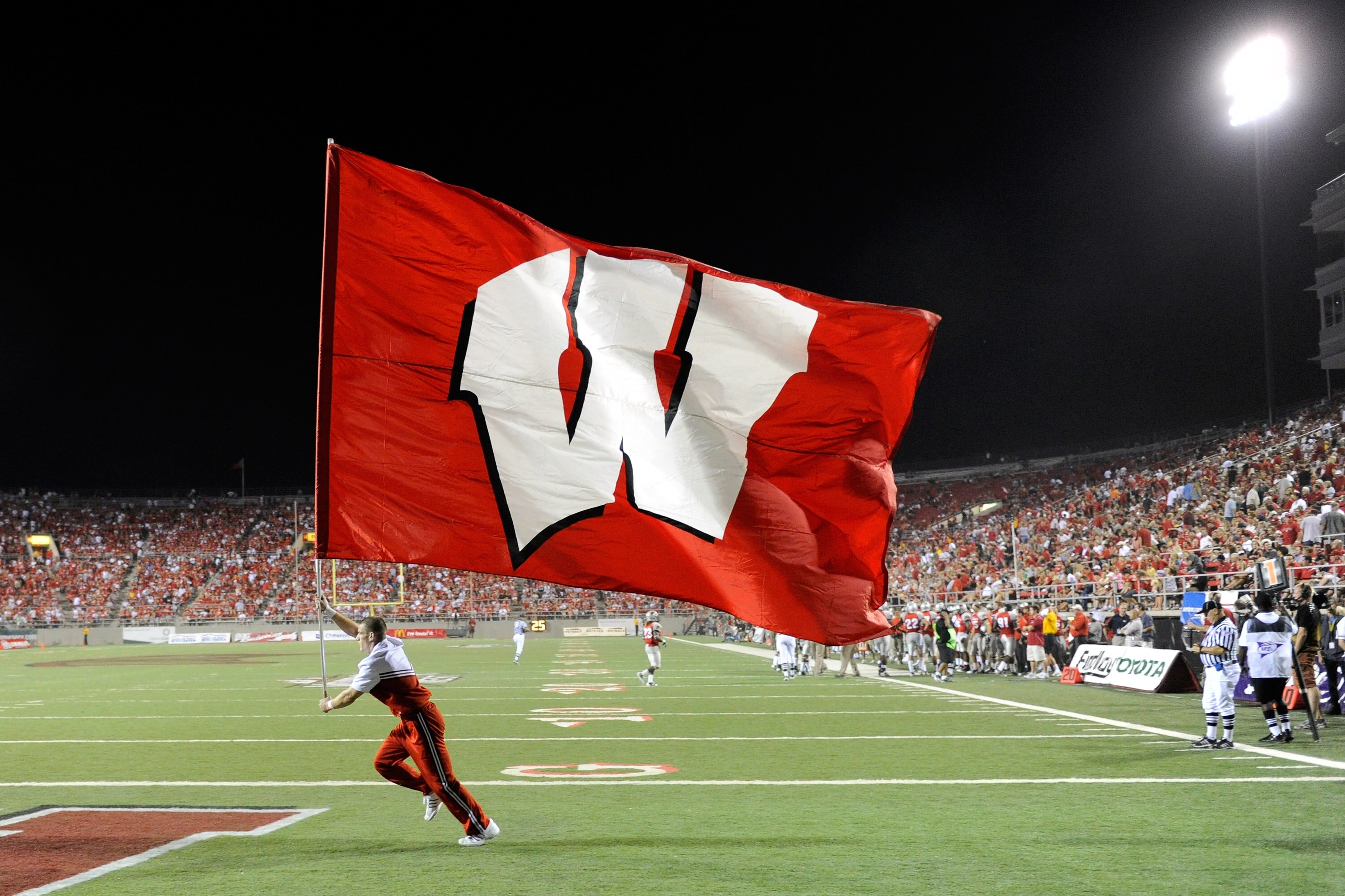 LAS VEGAS - SEPTEMBER 04:  A Wisconsin Badgers cheerleader runs a flag through the end zone after a Wisconsin touchdown against the UNLV Rebels at Sam Boyd Stadium September 4, 2010 in Las Vegas, Nevada. Wisconsin won 41-21.  (Photo by Ethan Miller/Getty