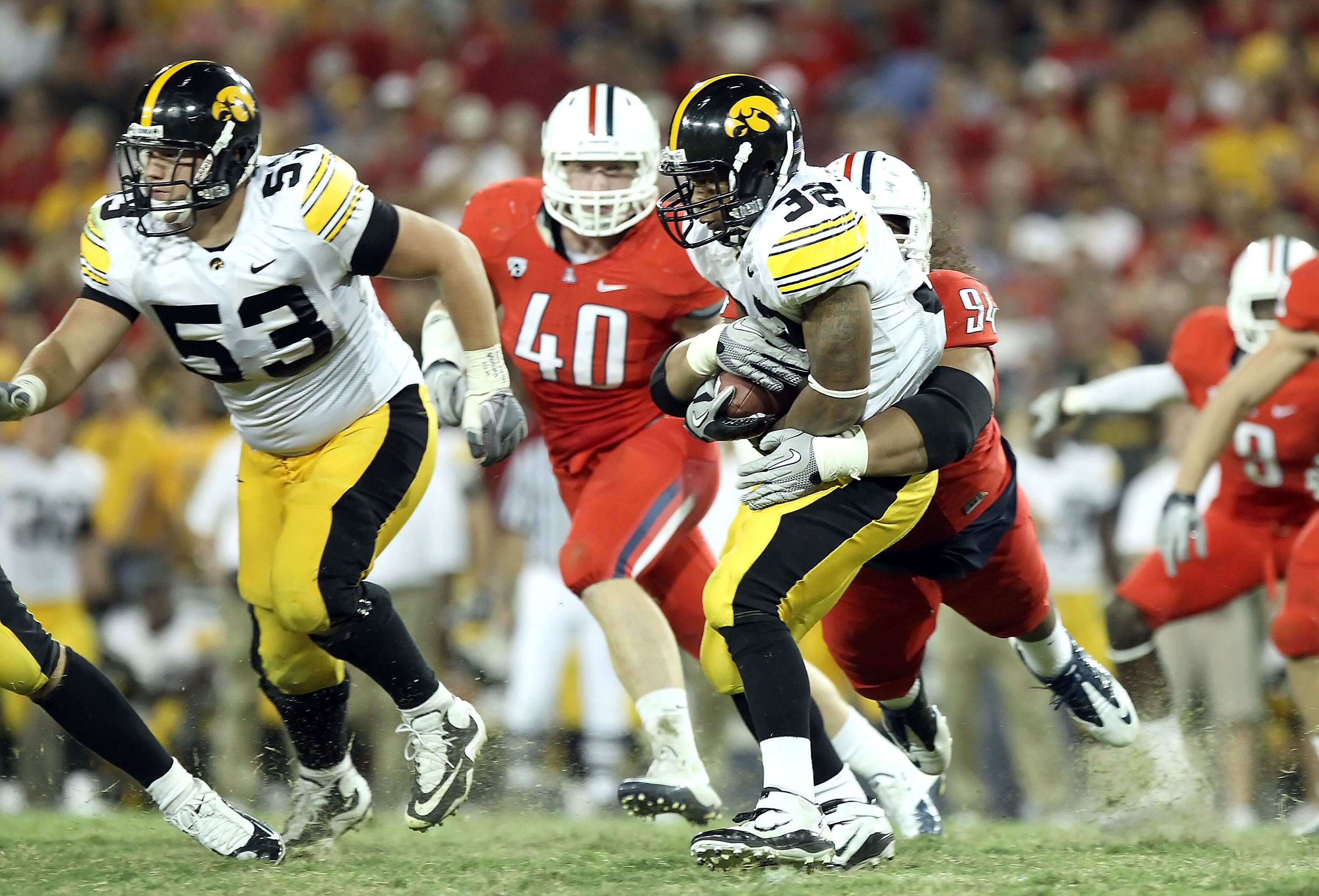 TUCSON, AZ - SEPTEMBER 18:  Runningback Adam Robinson #32 of the Iowa Hawkeyes is tackled for a 2 yard loss by Lolomana Mikaele #94 of the Arizona Wildcats during the college football game at Arizona Stadium on September 18, 2010 in Tucson, Arizona.  The 