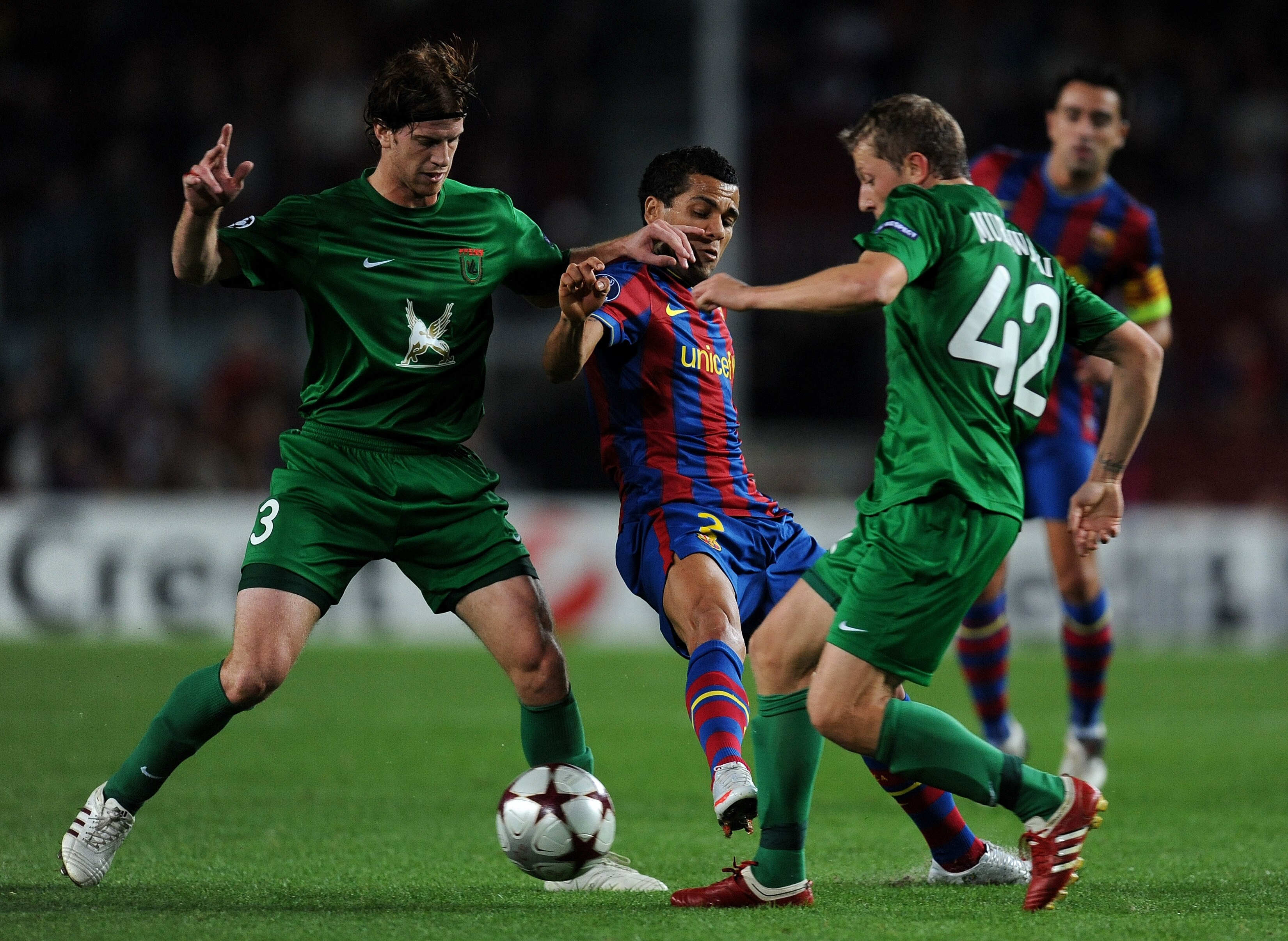 BARCELONA, SPAIN - OCTOBER 20:  Daniel Alves (C) of FC Barcelona duels for the ball with Cristian Ansaldi (L) and Rafal Murawski of FC Rubin Kazan during the UEFA Champions League group F match between FC Barcelona and FC Rubin Kazan at the Camp Nou Stadi