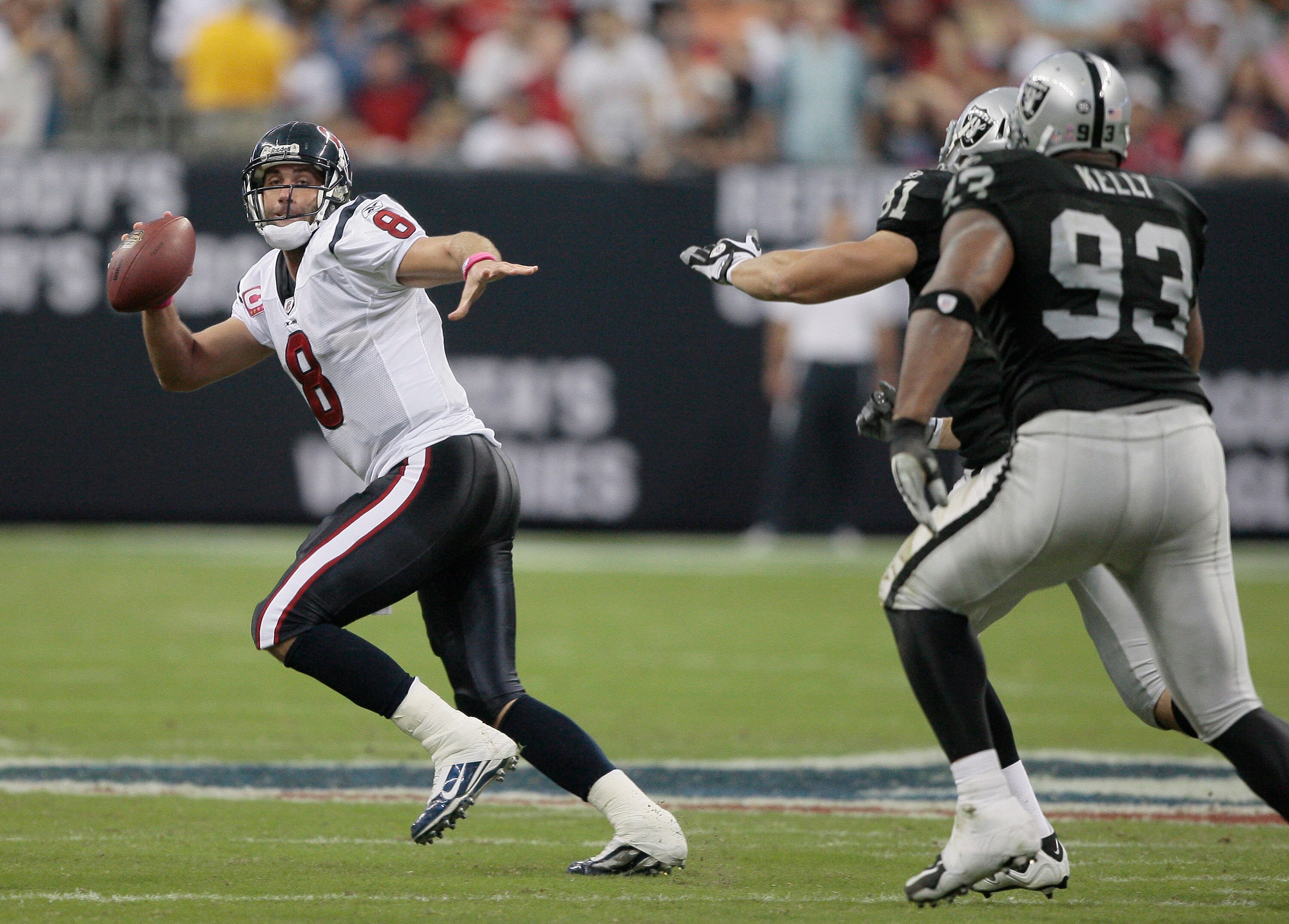 HOUSTON - OCTOBER 04:  Quarterback Matt Schaub #8 of the Houston Texans avoids pressure from defenive tackle Tommy Kelly #93 and Gerard Warren #61 of the Oakland Raiders at Reliant Stadium on October 4, 2009 in Houston, Texas.  (Photo by Bob Levey/Getty I