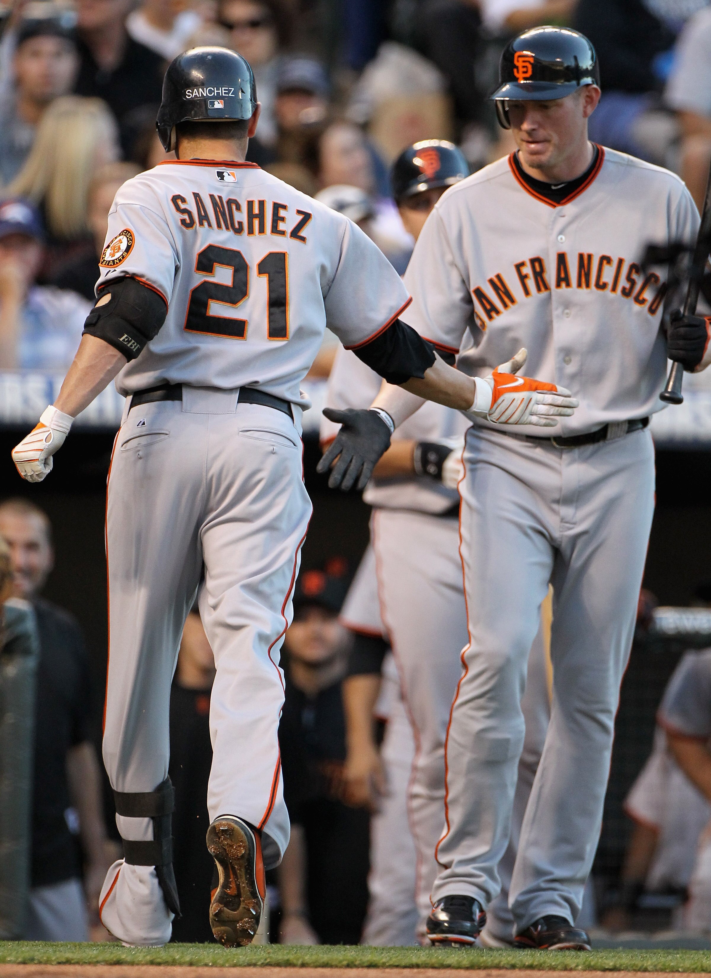 DENVER - SEPTEMBER 25:  Freddy Sanchez #21 of the San Francisco Giants is welcomed home by Aubrey Huff #17 after his first inning solo homerun off of starting pitcher Jason Hammel of the Colorado Rockies at Coors Field on September 25, 2010 in Denver, Col