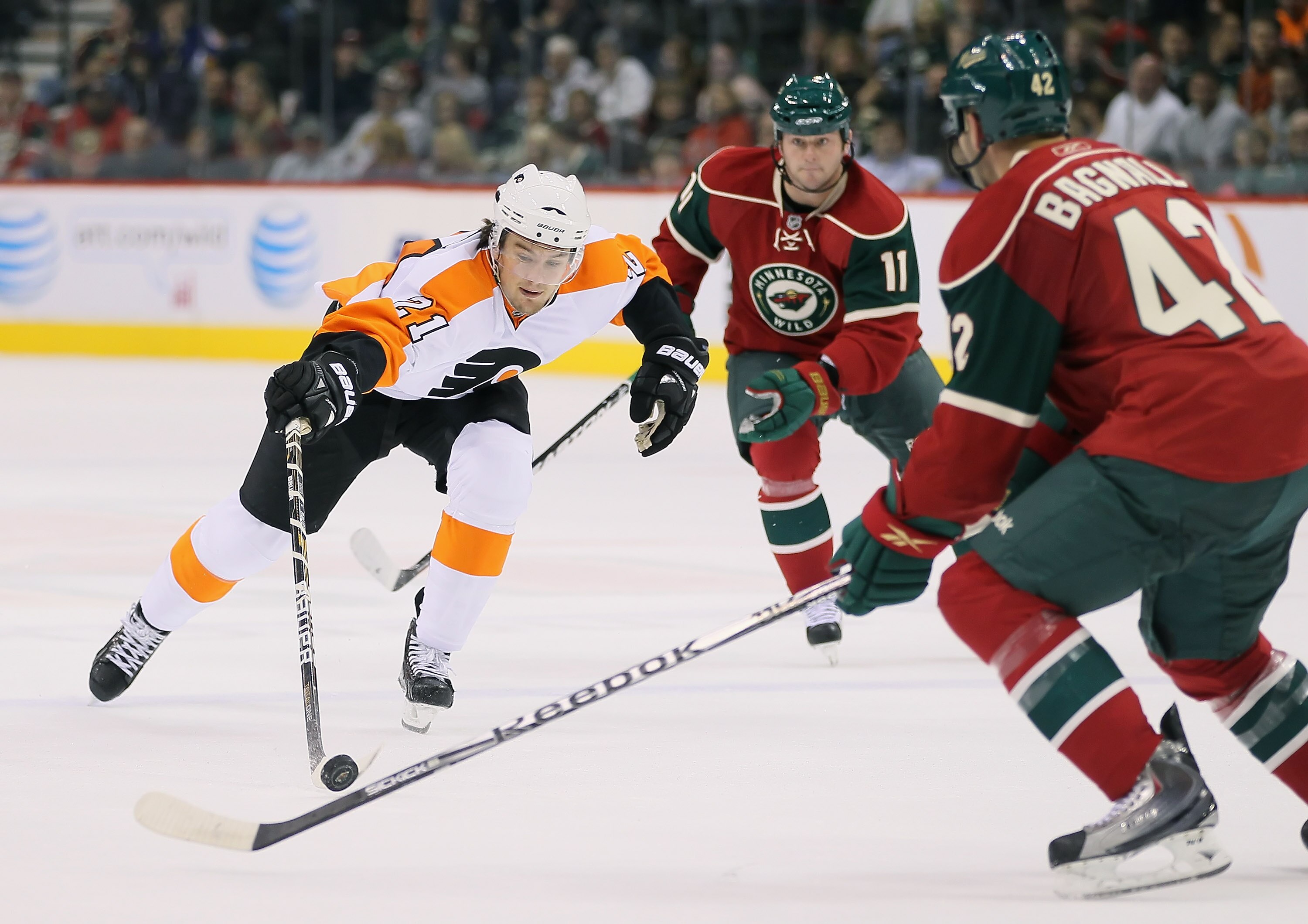 ST PAUL, MN - SEPTEMBER 25:  James Van Riemsdyk #21 of the Philadelphia Flyers lunges for the puck as John Madden #11 and Drew Bagnall #42 of the Minnesota Wild defend during the third period at Xcel Energy Center on September 25, 2010 in St Paul, Minneso