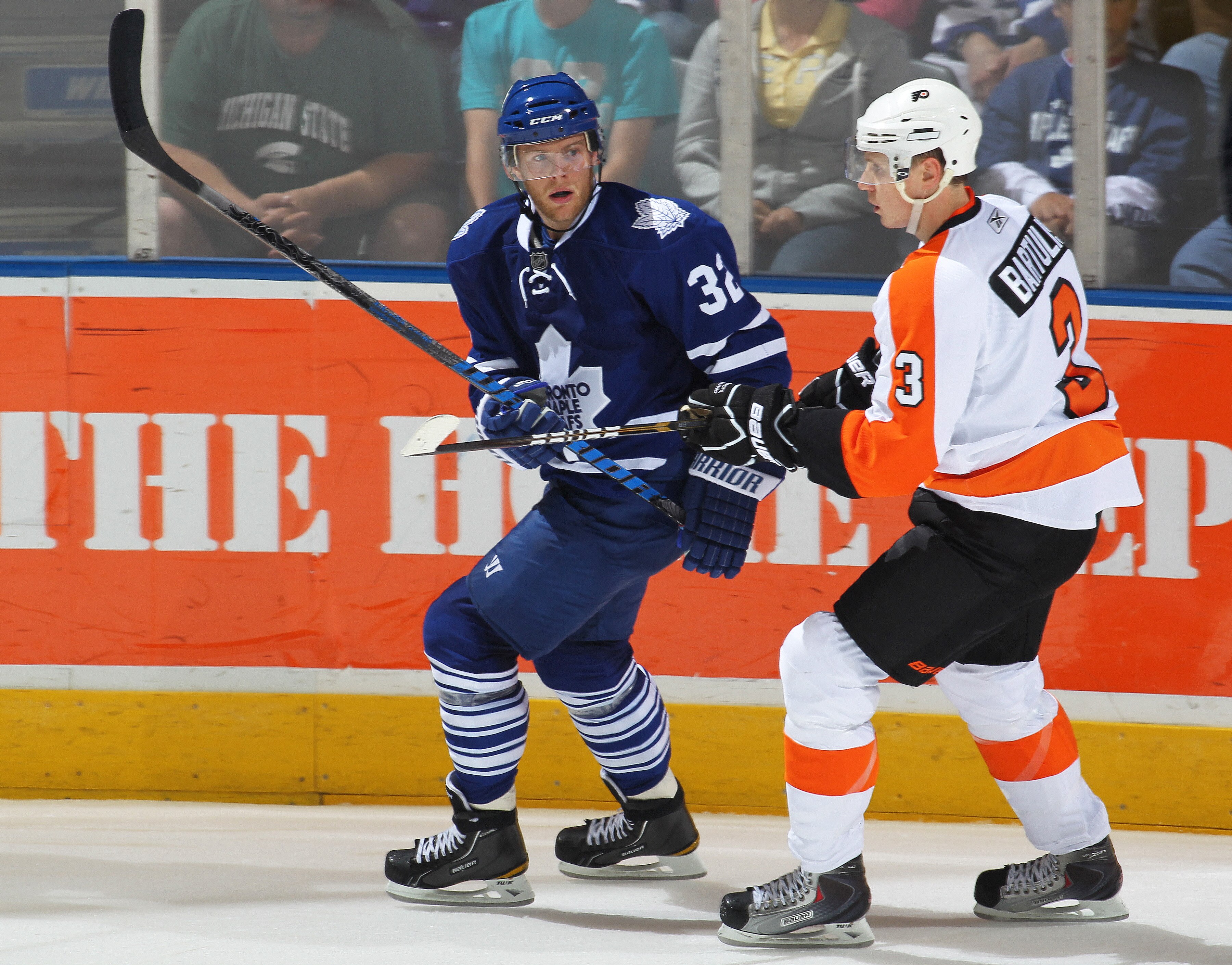 LONDON,ON - SEPTEMBER 23: Kris Versteeg #32 of the Toronto Maple Leafs is held in check by Oskars Bartulis #3 of the Philadelphia Flyers in a pre-season game on September 23,2010 at the John Labatt Centre in London, Ontario. The Leafs defeated the Flyers