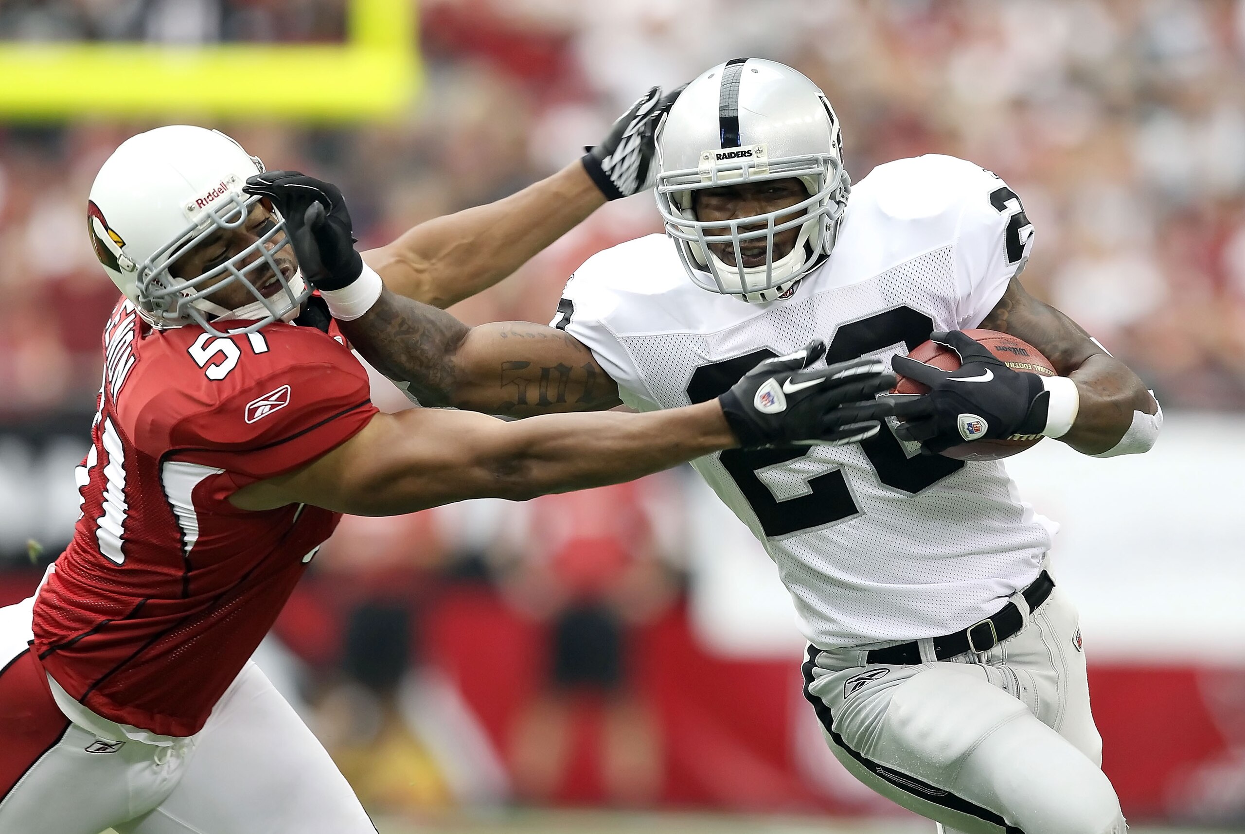GLENDALE, AZ - SEPTEMBER 26:  Runningback Darren McFadden #20 of the Oakland Raiders rushes the football past Paris Lenon #51 of the Arizona Cardinals during the first quarter of the NFL game at the University of Phoenix Stadium on September 26, 2010 in G