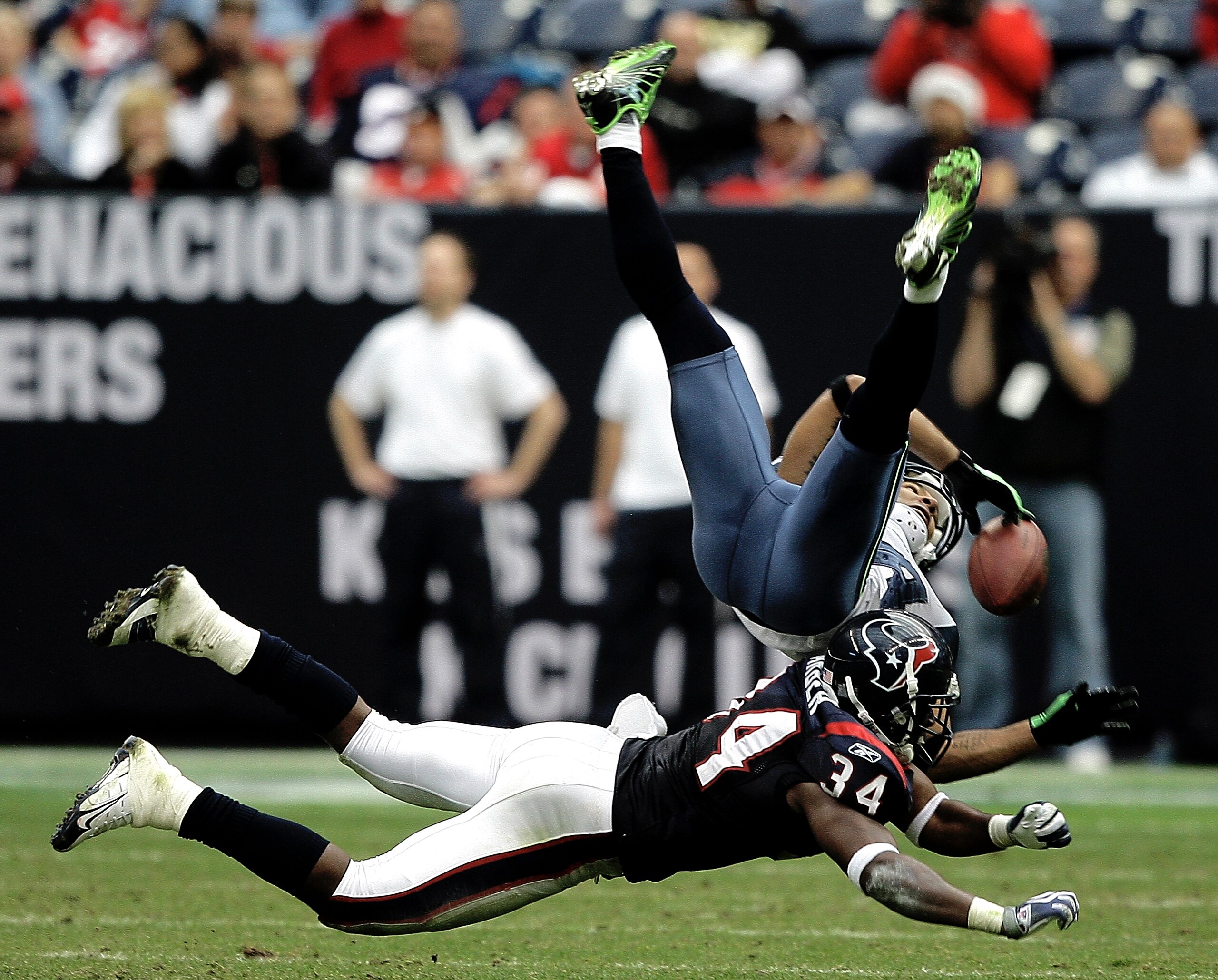 HOUSTON - DECEMBER 13:  Wide receiver T.J. Houshmandzadeh #84 of the Seattle Seahawks has the ball knocked loose by strong safety Dominique Barber #34 of the Houston Texans in the fourth quarter at Reliant Stadium on December 13, 2009 in Houston, Texas. T