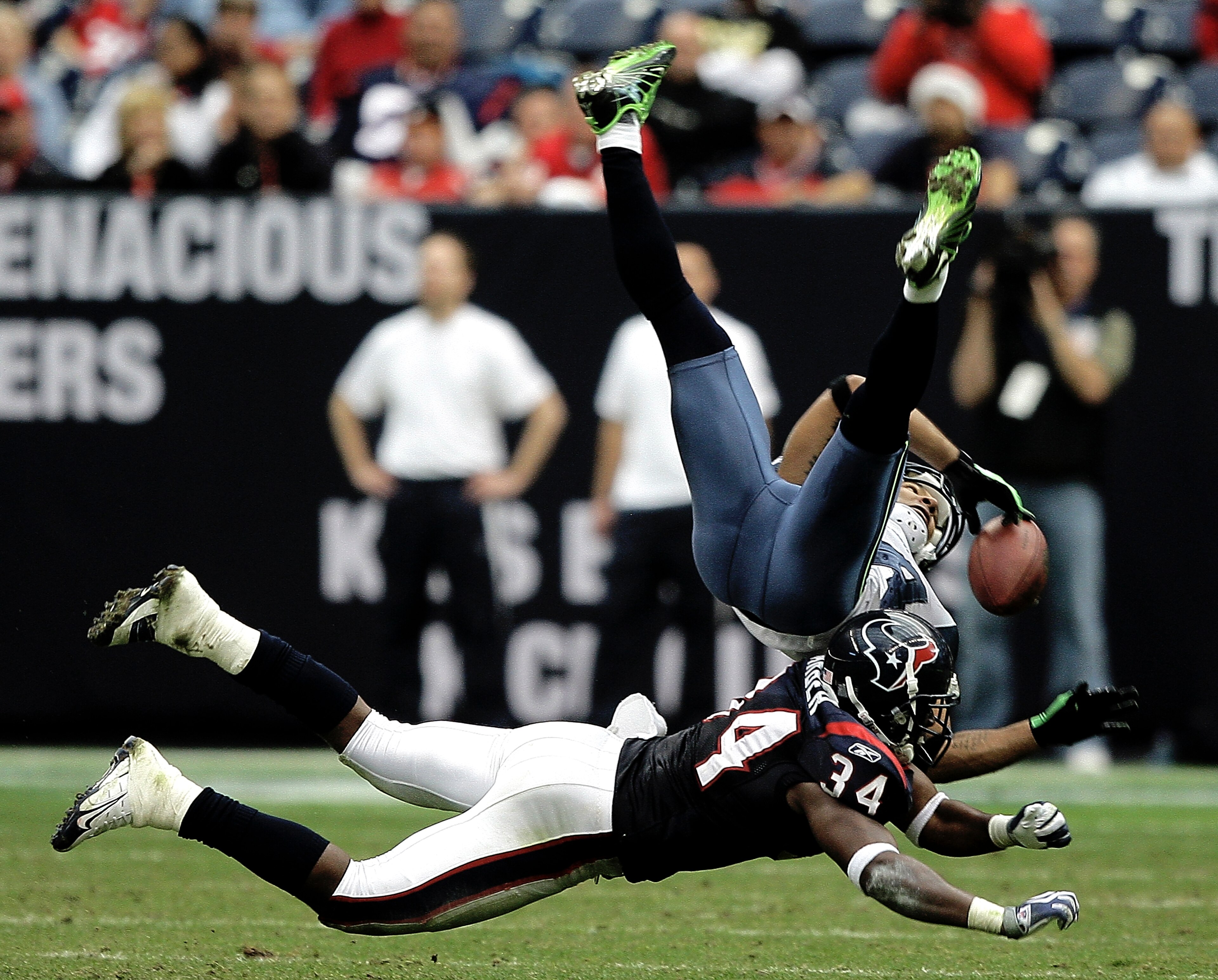 HOUSTON - DECEMBER 13:  Wide receiver T.J. Houshmandzadeh #84 of the Seattle Seahawks has the ball knocked loose by strong safety Dominique Barber #34 of the Houston Texans in the fourth quarter at Reliant Stadium on December 13, 2009 in Houston, Texas. T