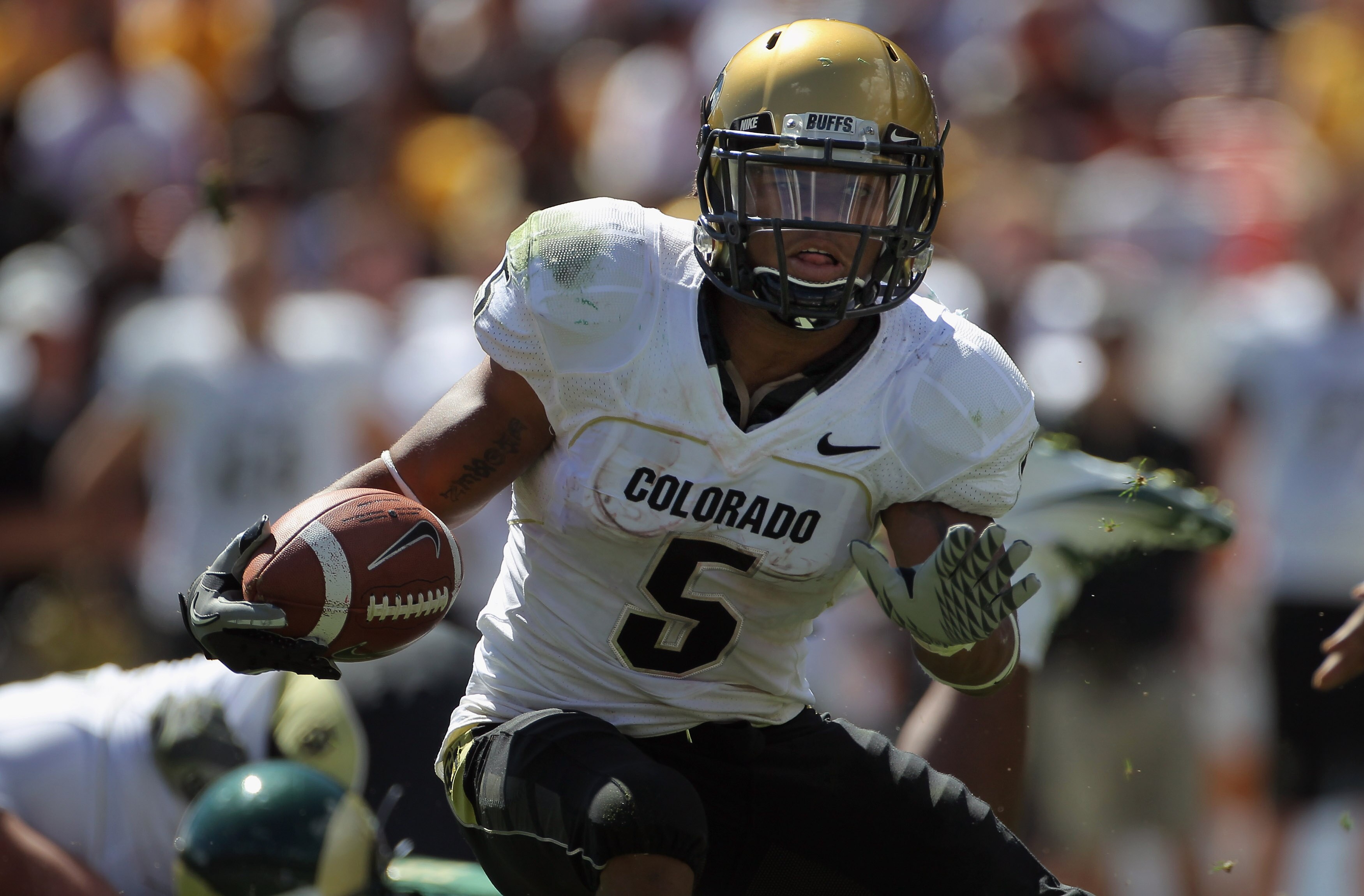 DENVER - SEPTEMBER 04:  Running back Rodney Stewart #5 of the Colorado Buffaloes picks up yardage as he rushes against the Colorado State Rams during the the Rocky Mountain Showdown at INVESCO Field at Mile High on September 4, 2010 in Denver, Colorado.  
