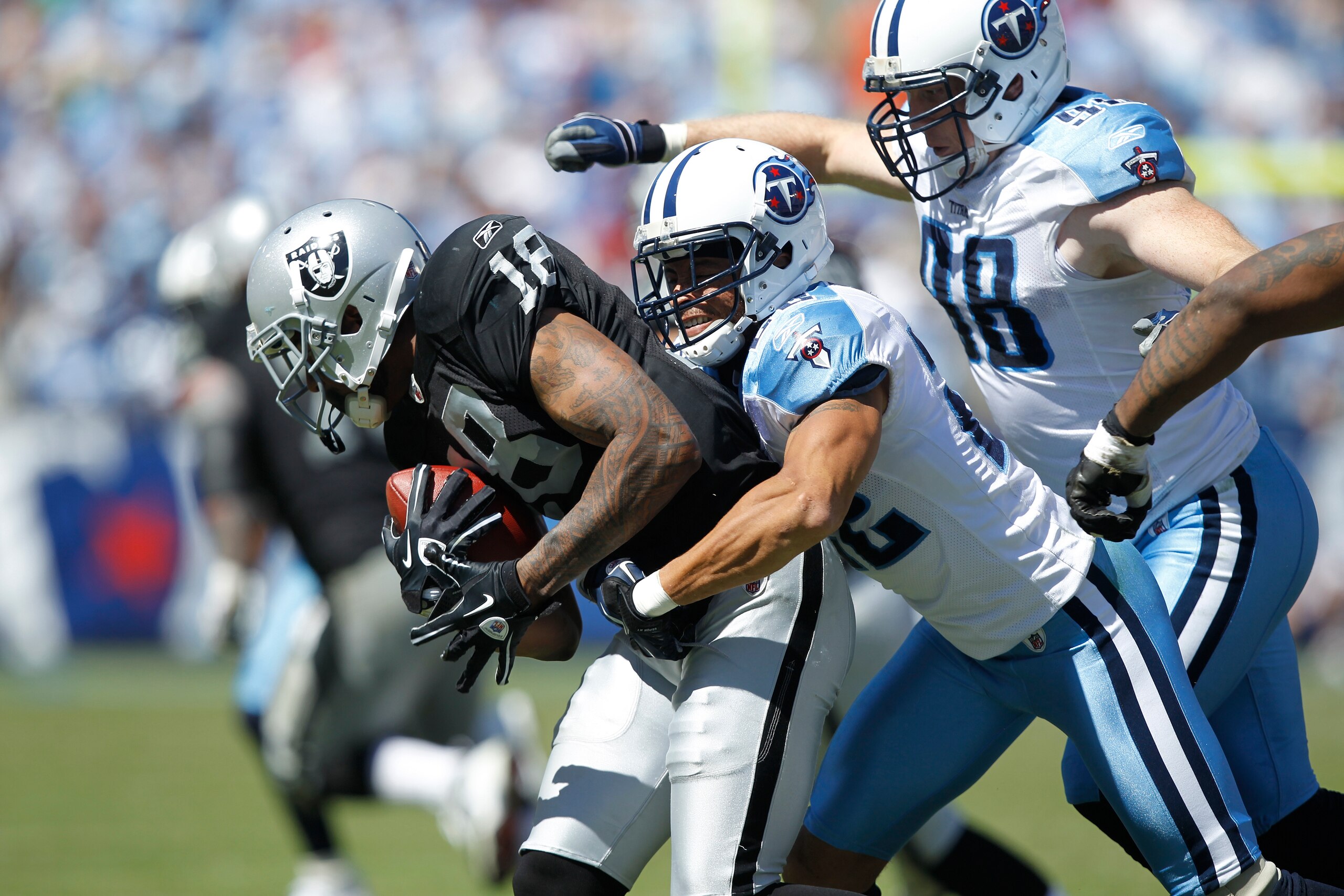 NASHVILLE - SEPTEMBER 12: Vincent Fuller #22 and Dave Ball #98 of the Tennessee Titans tackle Louis Murphy #18 of the Oakland Raiders during the NFL season opener at LP Field on September 12, 2010 in Nashville, Tennessee. The Titans defeated the Raiders 3