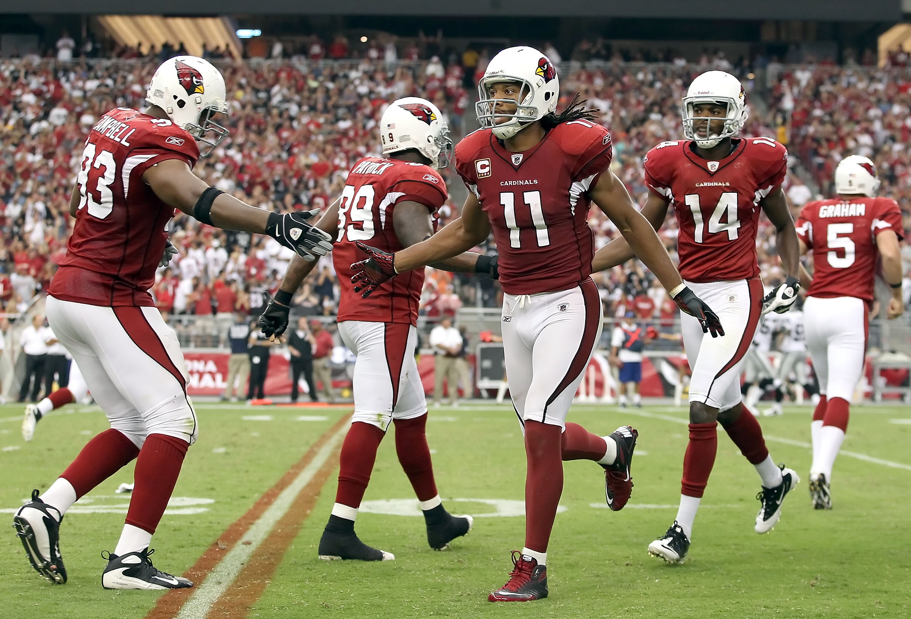 GLENDALE, AZ - SEPTEMBER 26:  Wide receiver Larry Fitzgerald #11 of the Arizona Cardinals celebrates with teammates after scoring on a 8 yard touchdown reception against the Oakland Raiders during the thrid quarter of the NFL game at the University of Pho