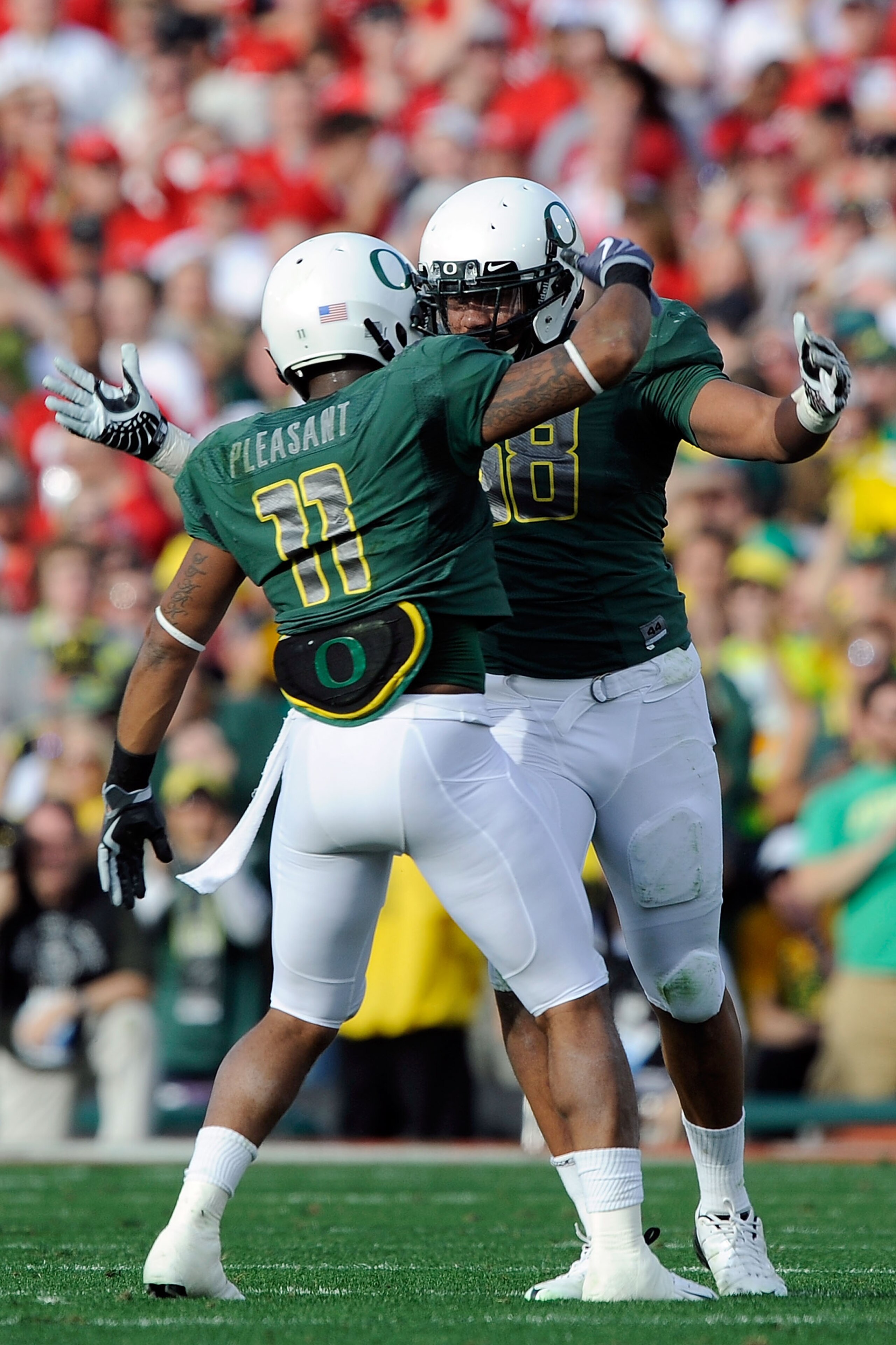 PASADENA, CA - JANUARY 01:  Linebacker Kenny Rowe #58 of the Oregon Ducks celebrates a sack with linebacker Eddie Pleasant #11 during the game against the Ohio State Buckeyes at the 96th Rose Bowl game on January 1, 2010 in Pasadena, California.  (Photo b