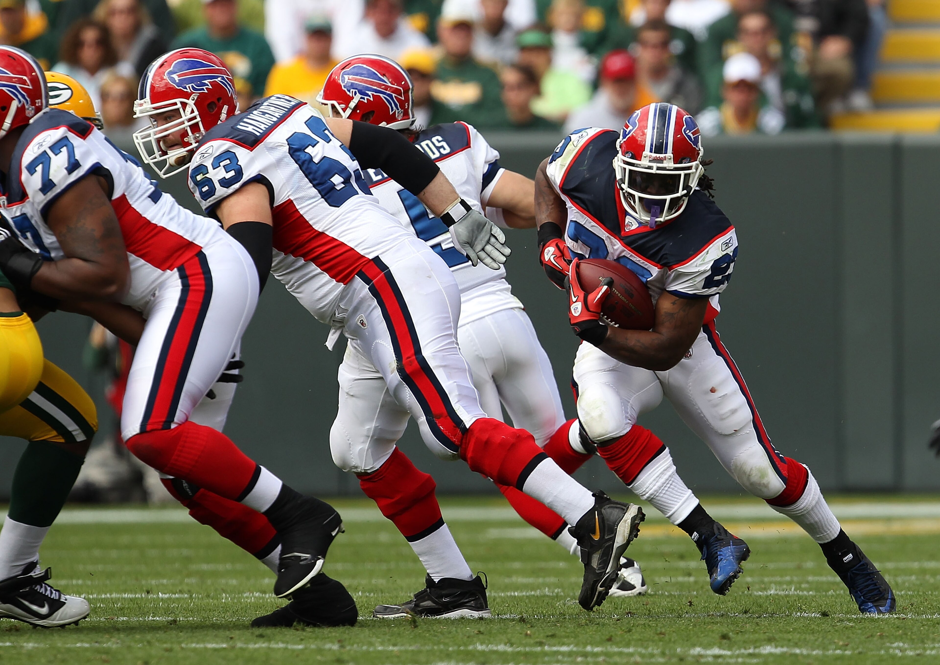 GREEN BAY, WI - SEPTEMBER 19: Marshawn Lynch #23 of the Buffalo Bills runs as teammates Demetrius Bell #77 and Geoff Hangartner #63 block against the Green Bay Packers at Lambeau Field on September 19, 2010 in Green Bay, Wisconsin. The Packers defeated th GREEN BAY, WI - SEPTEMBER 19: Marshawn Lynch #23 of the Buffalo Bills runs as teammates Demetrius Bell #77 and Geoff Hangartner #63 block against the Green Bay Packers at Lambeau Field on September 19, 2010 in Green Bay, Wisconsin. The Packers defeated th
