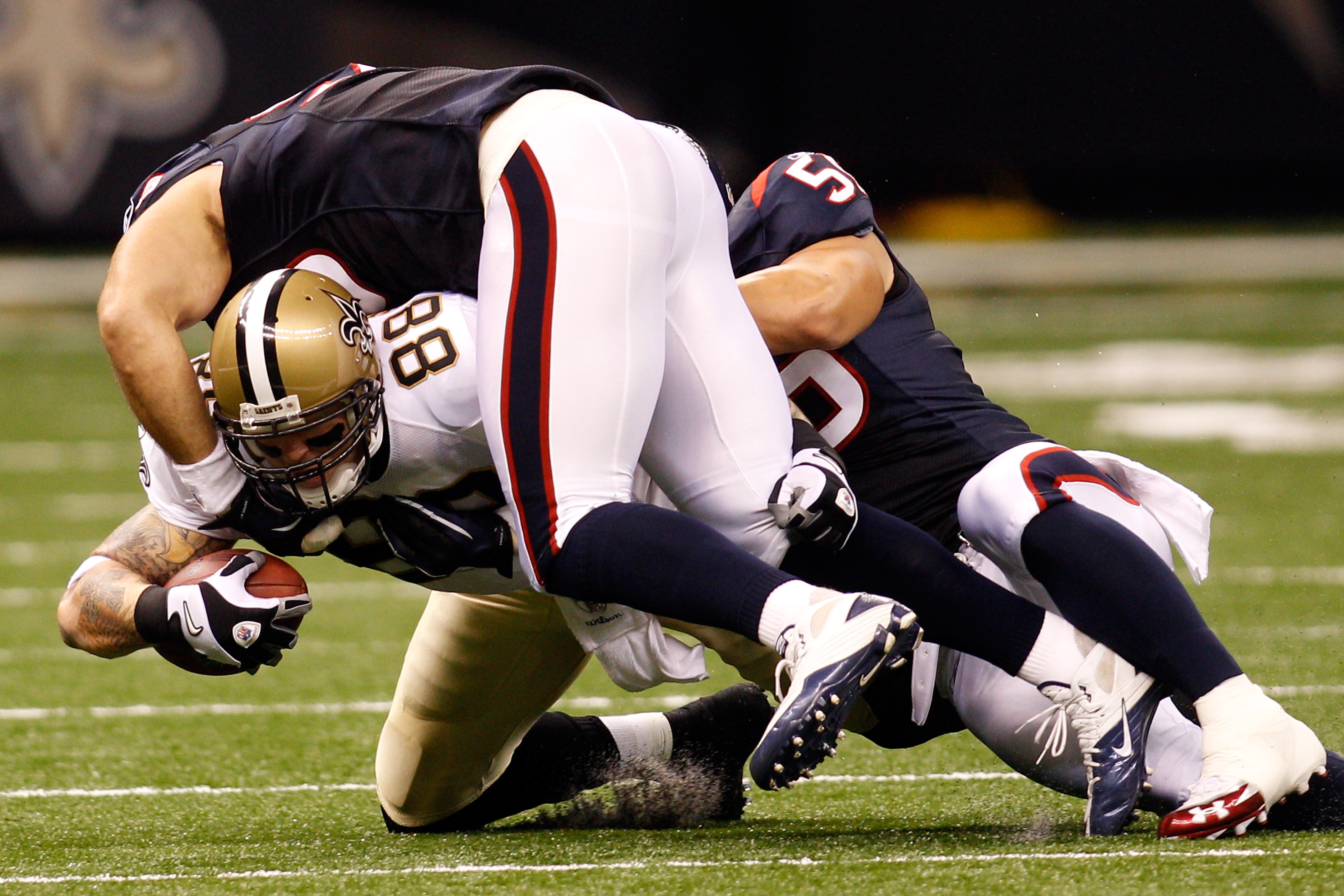 NEW ORLEANS - AUGUST 21:  Jeremy Shockey #88 of the New Orleans Saints is tackled by Connor Barwin #98 and Brian Cushing # 56 of the Houston Texans at the Louisiana Superdome on August 21, 2010 in New Orleans, Louisiana.  (Photo by Chris Graythen/Getty Im