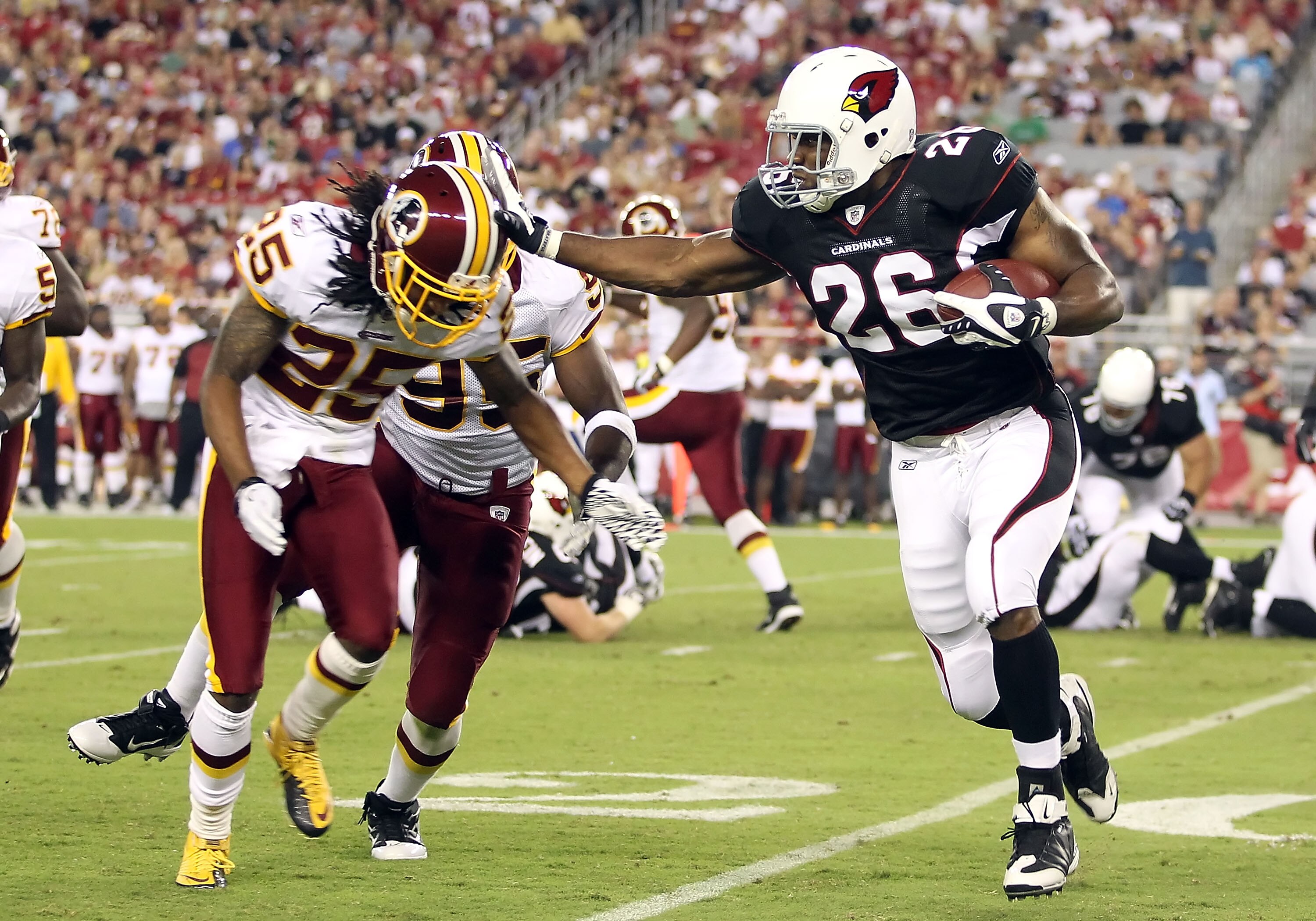 GLENDALE, AZ - SEPTEMBER 02:  Runningback Beanie Wells #26 of the Arizona Cardinals rushes the football against Chris Wilson #95 and Kevin Barnes #25 of the Washington Redskins during the first quarter of the preseason NFL game at the University of Phoeni