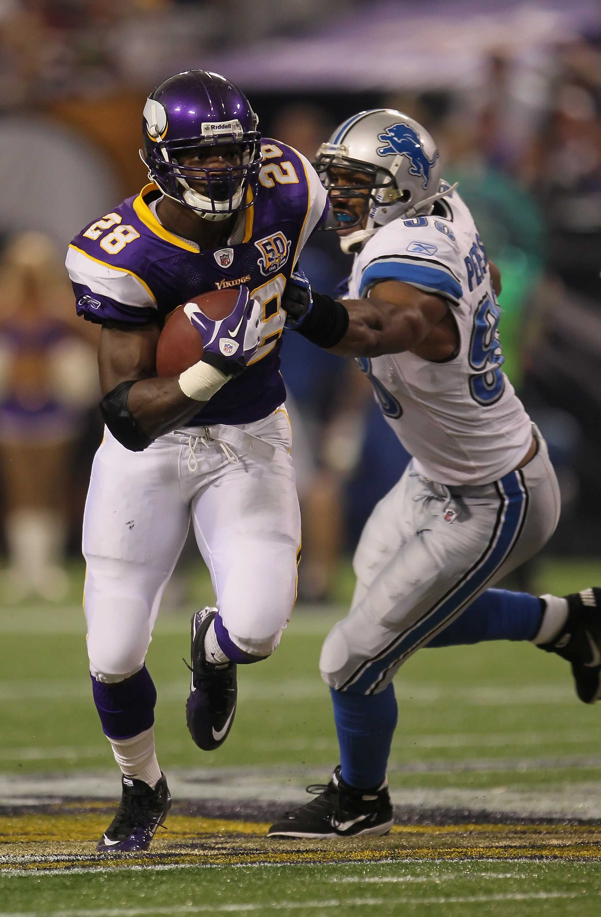MINNEAPOLIS - SEPTEMBER 26:  Running back Adrian Peterson #28 of the Minnesota Vikings carries the ball while being pursued by Julian Peterson #98 of the Detroit Lions during the second half at Hubert H. Humphrey Metrodome on September 26, 2010 in Minneap