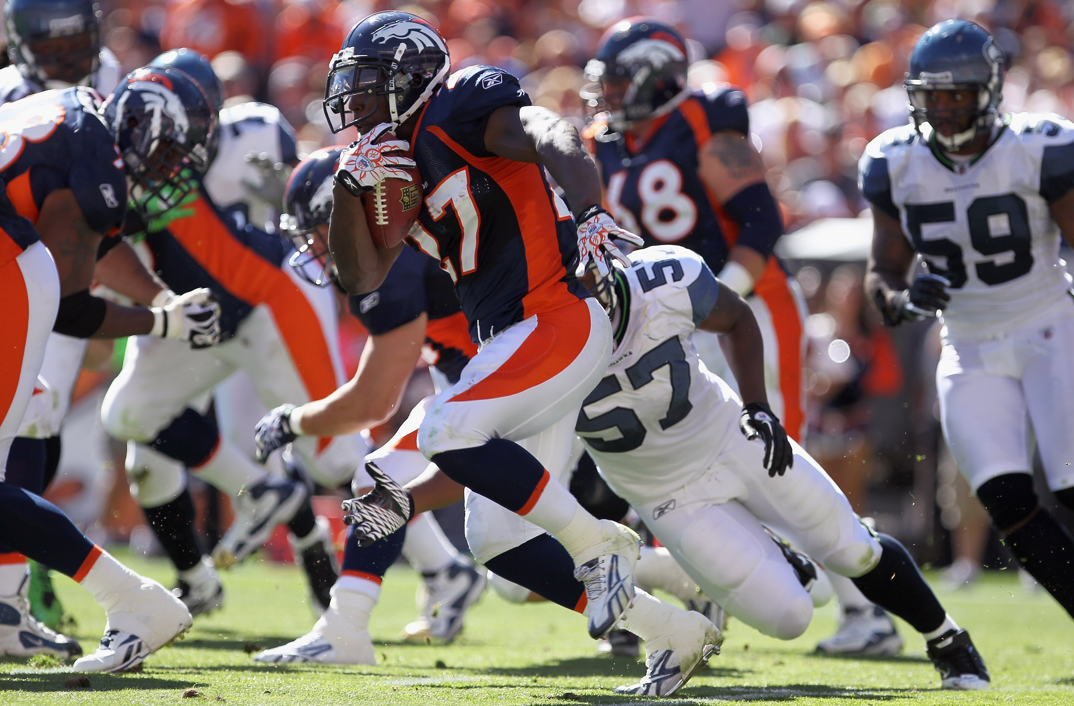 DENVER - SEPTEMBER 19:  Running back Knowshon Moreno #27 of the Denver Broncos picks up yardage as he eludes linebacker David Hawthorne #57 of the Seattle Seahawks at INVESCO Field at Mile High on September 19, 2010 in Denver, Colorado.  (Photo by Doug Pe