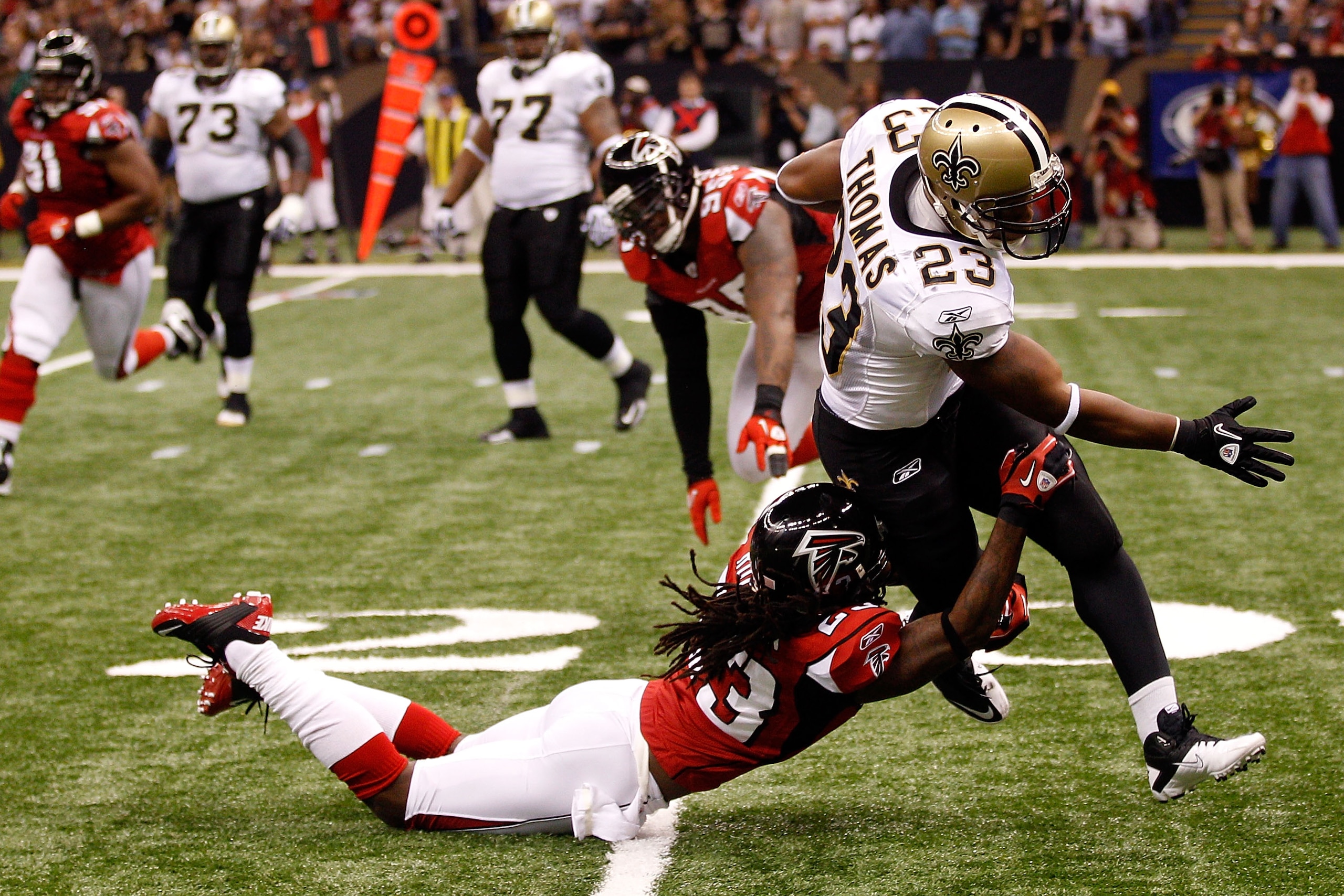 NEW ORLEANS - SEPTEMBER 26:  Pierre Thomas #23 of the New Orleans Saints is tackled for a loss by Dunta Robinson #23 of the Atlanta Falcons at the Louisiana Superdome on September 26, 2010 in New Orleans, Louisiana.  (Photo by Chris Graythen/Getty Images)