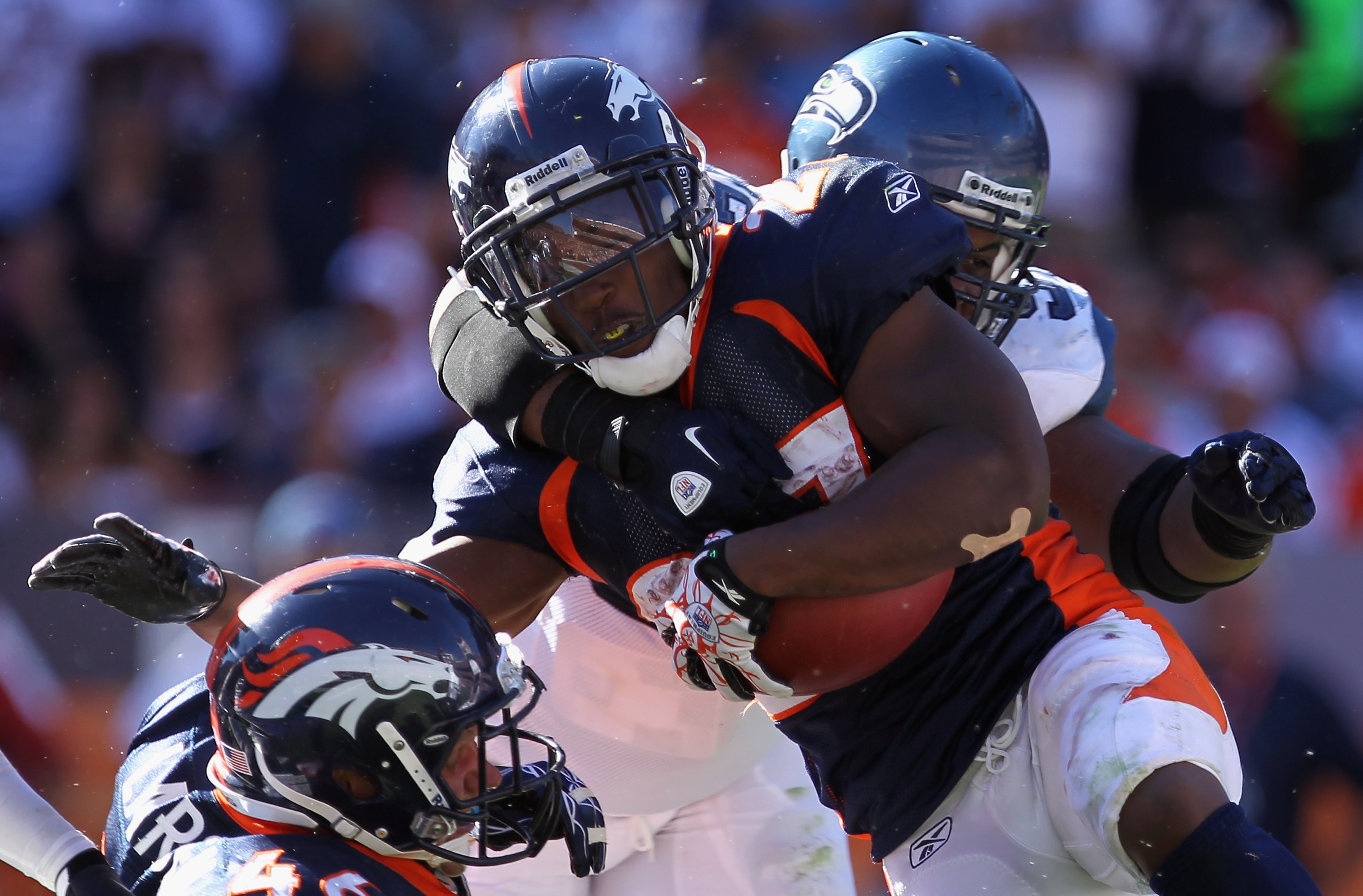 DENVER - SEPTEMBER 19:  Running back Knowshon Moreno #27 of the Denver Broncos is stopped by defensive tackle Brandon Mebane #92 of the Seattle Seahawks at INVESCO Field at Mile High on September 19, 2010 in Denver, Colorado. The Broncos defeated the Seah