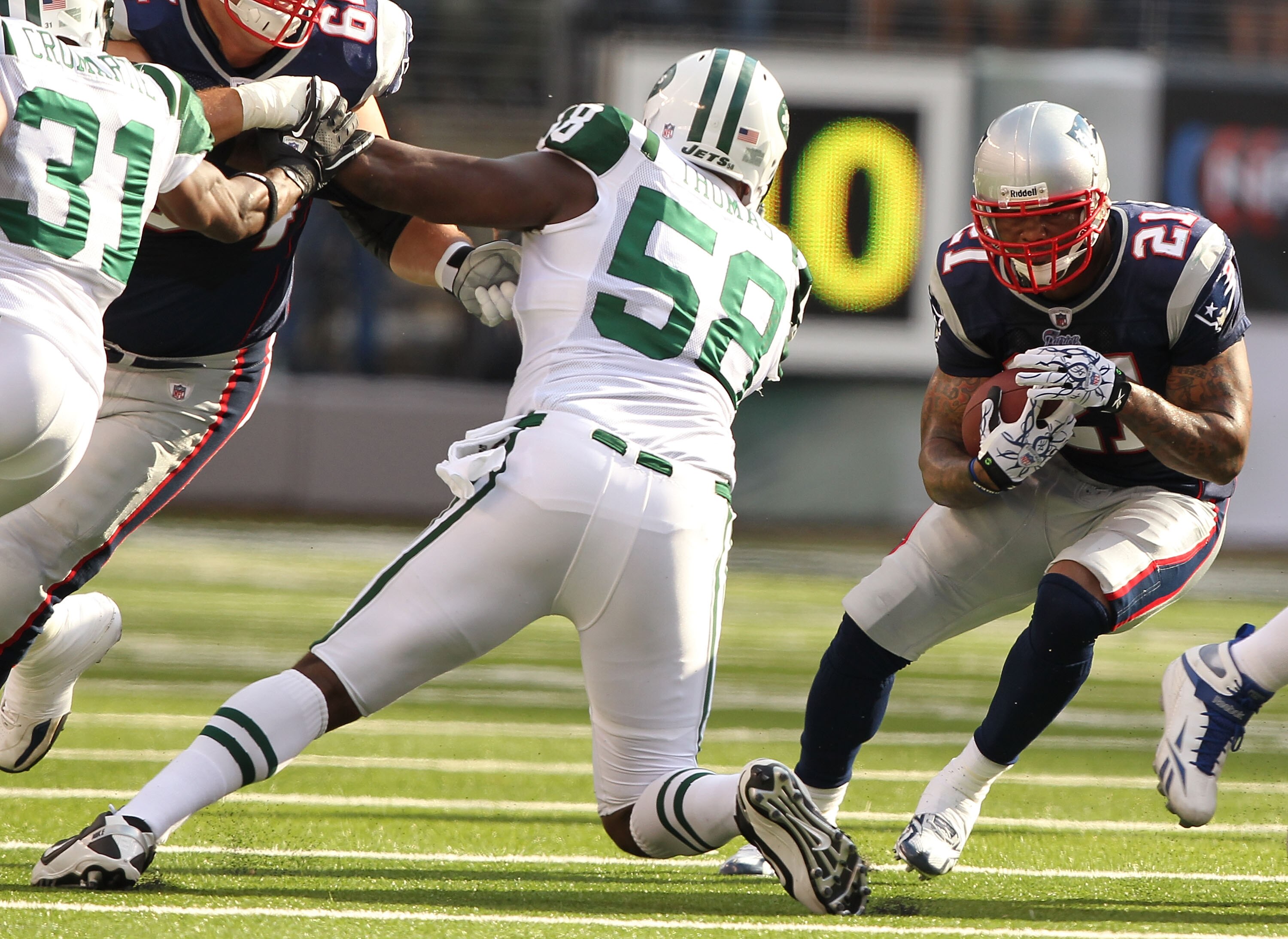 EAST RUTHERFORD, NJ - SEPTEMBER 19:  Bryan Thomas #58 of the New York Jets tackles Fred Taylor #21 of the New England Patriots during their  game on September 19, 2010 at the New Meadowlands Stadium  in East Rutherford, New Jersey.  (Photo by Al Bello/Get