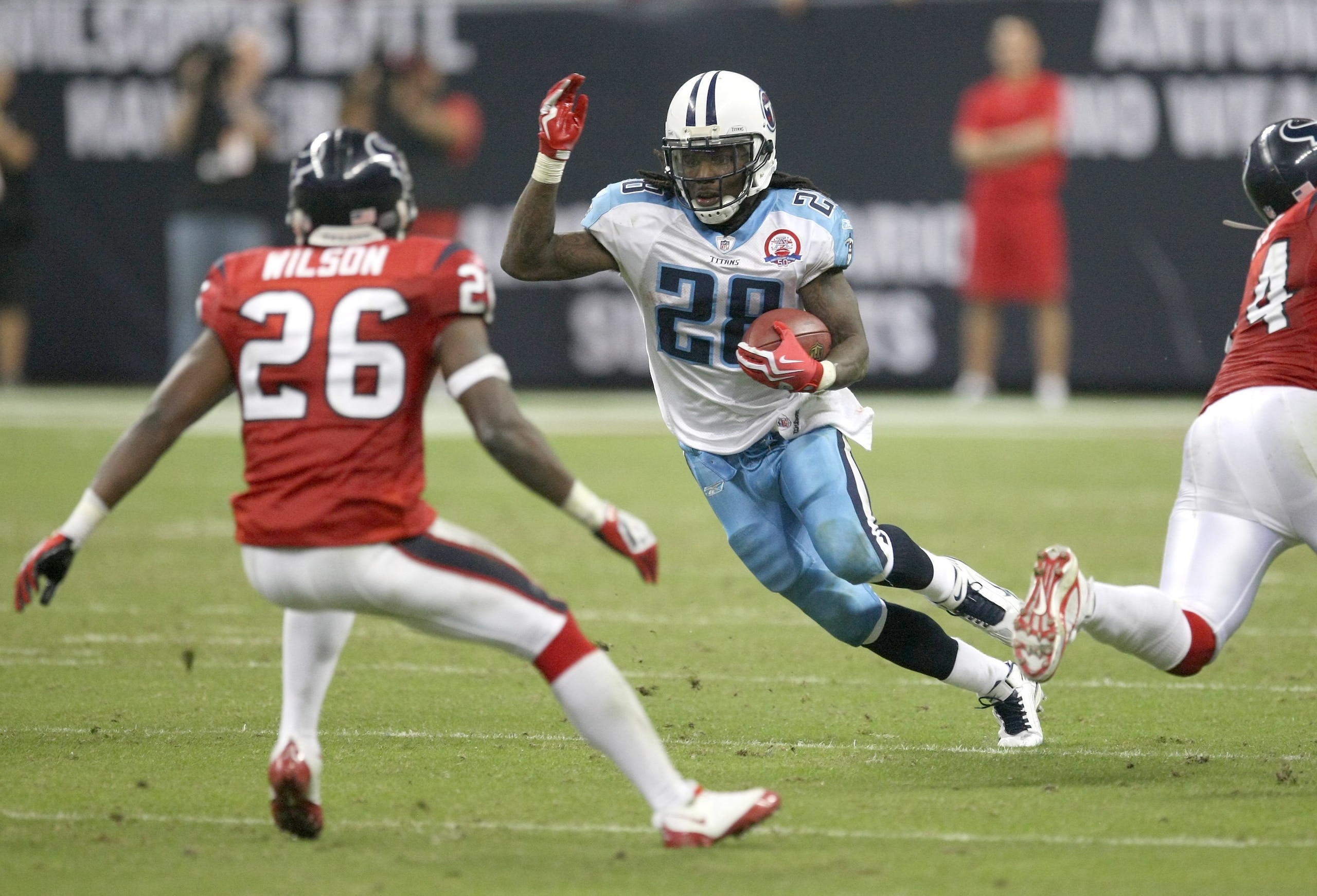 HOUSTON - NOVEMBER 23:  Running Back Chris Johnson #28 of the Tennessee Titans carries the ball against safety Eugene Wilson #26 of the Houston Texans on November 23, 2009  at Reliant Stadium in Houston, Texas.  The Titans won 20-17.  (Photo by Stephen Du