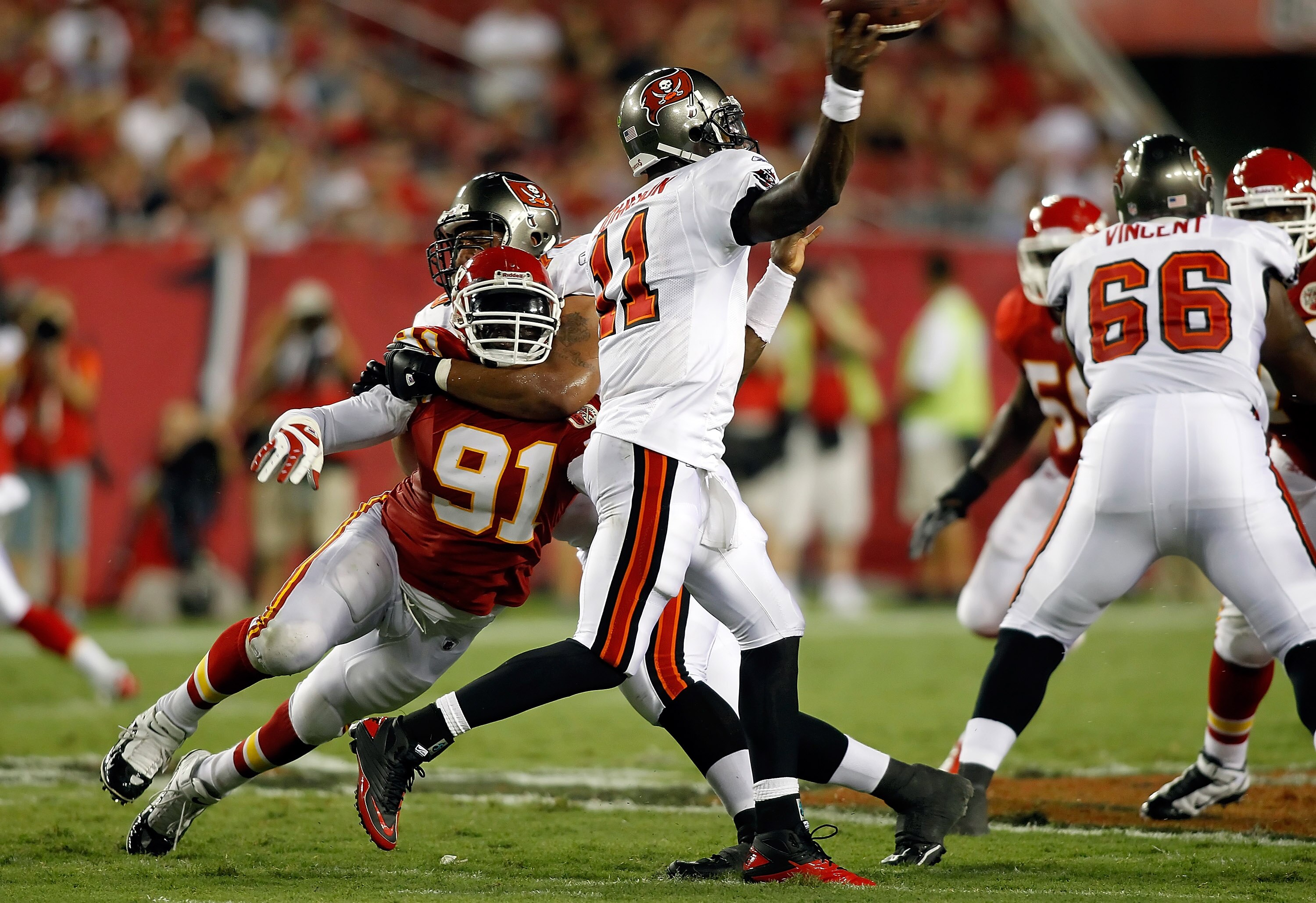 TAMPA, FL - AUGUST 21:  Quarterback Josh Johnson #11 of the Tampa Bay Buccaneers gets this pass off as defender Tamba Hali #91 of the Kansas City Chiefs closes in during a preseason game at Raymond James Stadium on August 21, 2010 in Tampa, Florida.  (Pho