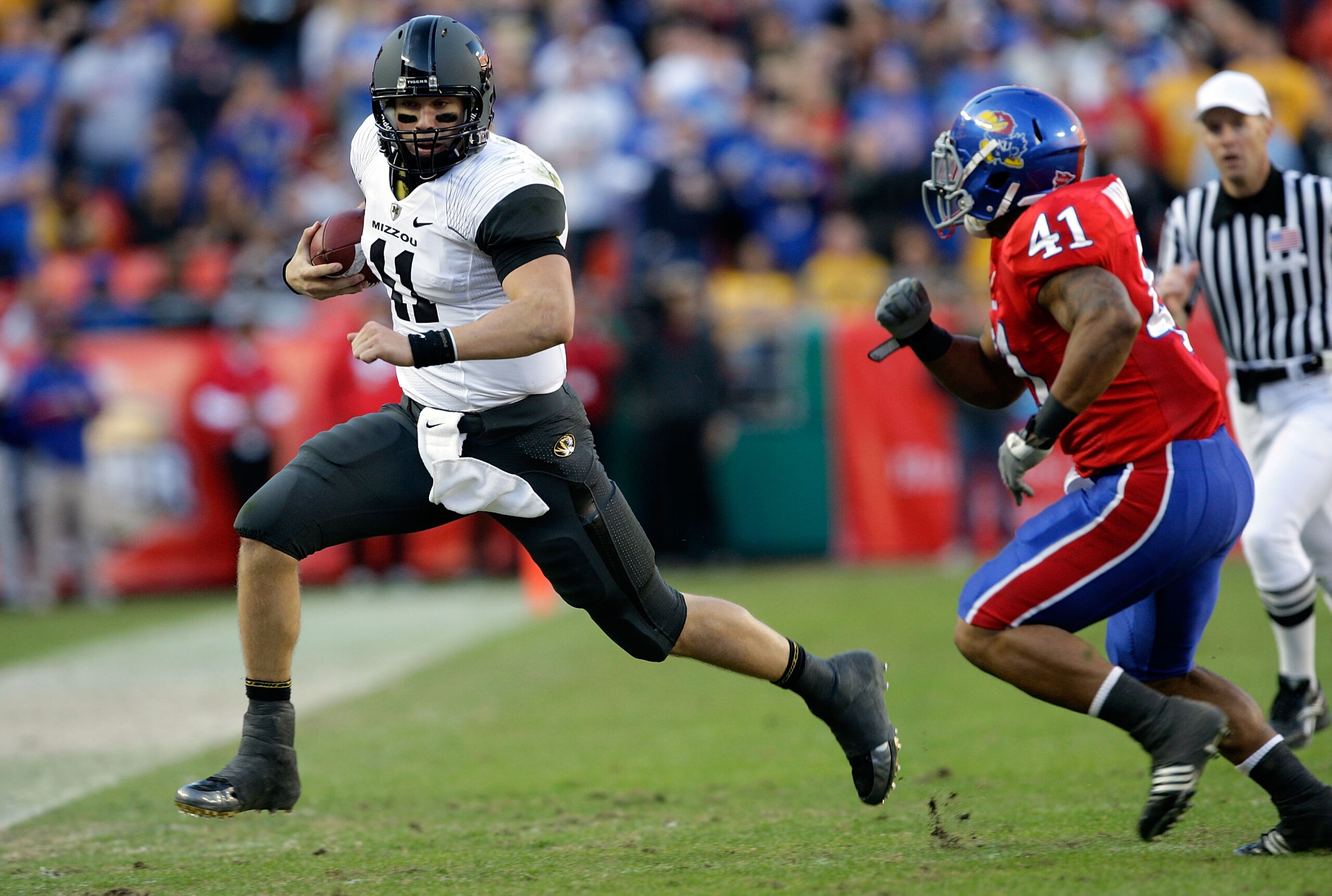 KANSAS CITY, MO - NOVEMBER 28:  Quarterback Blaine Gabbert #11 of the Missouri Tigers carries the ball toward the sidelines as Arist Wright #41 of the Kansas Jayhawks persues during the game at Arrowhead Stadium on November 28, 2009 in Kansas City, Missou