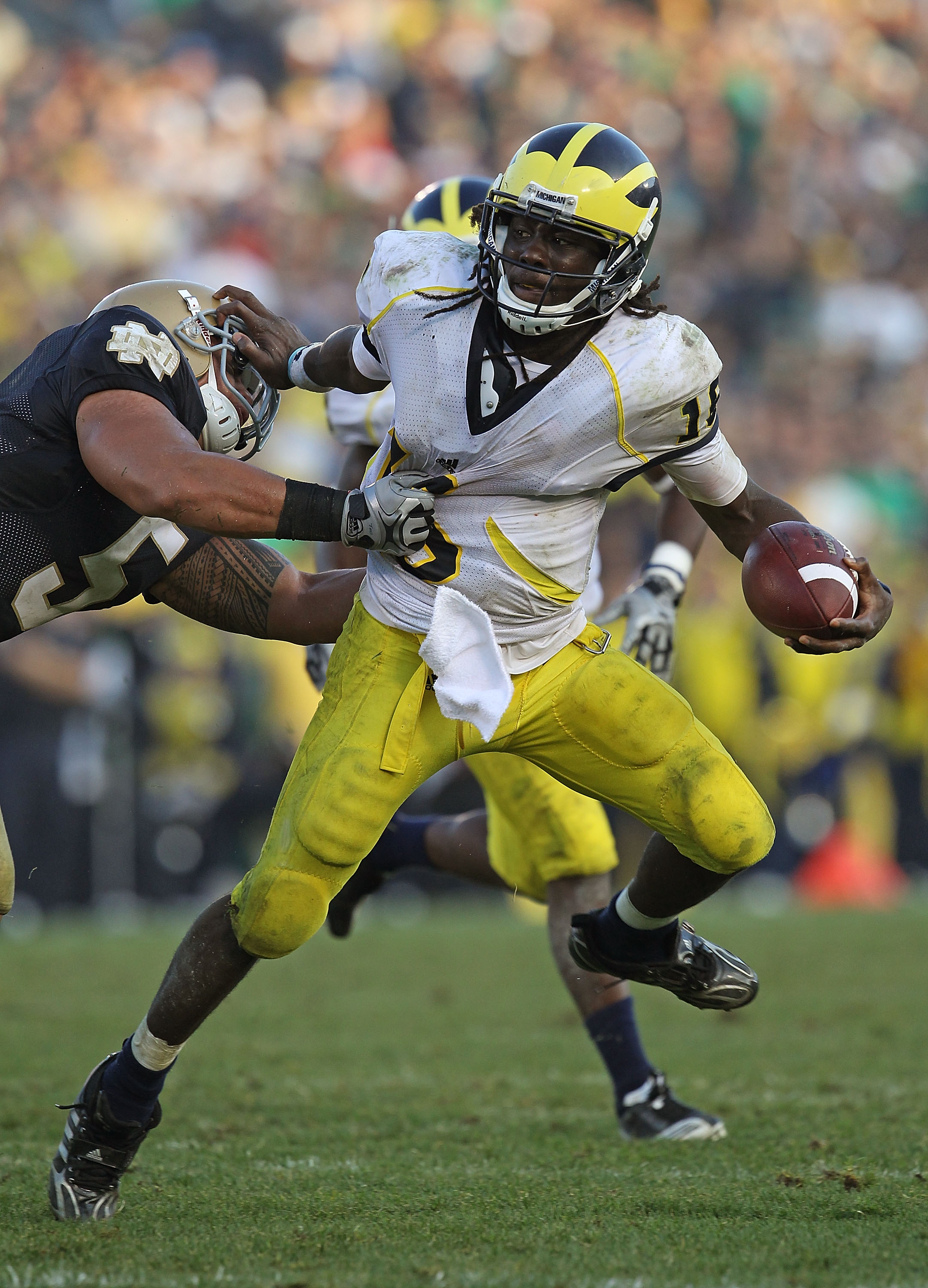 SOUTH BEND, IN - SEPTEMBER 11: Denard Robinson #16 of the Michigan Wolverines pushes off a tackle attempt by Manti Te'o #5 of the Notre Dame Fighting Irish in the final minute at Notre Dame Stadium on September 11, 2010 in South Bend, Indiana. Michigan de