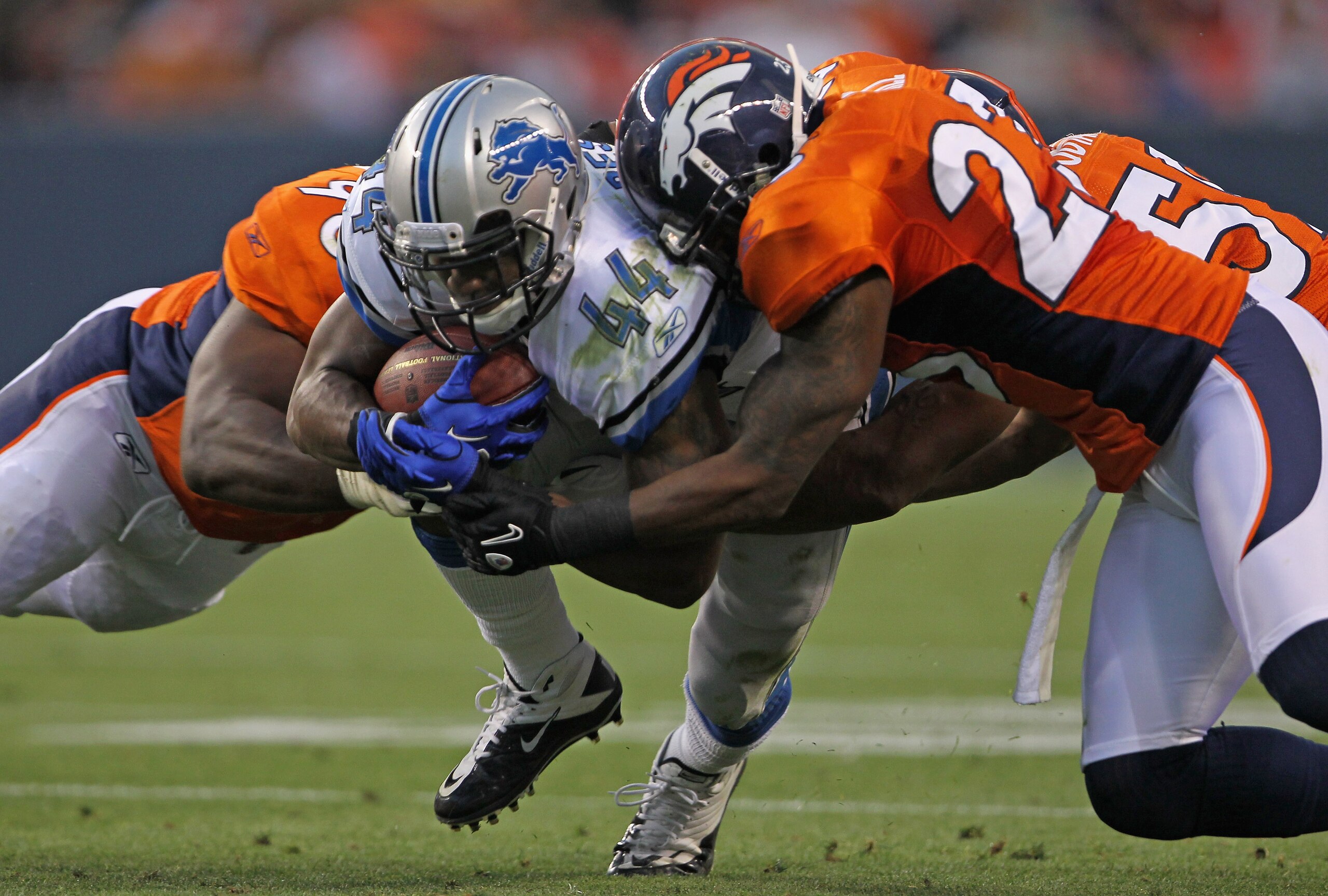 DENVER - AUGUST 21: Jahvid Best #44 of the Detroit Lions rushes the ball as Ryan McBean #98 and Renaldo Hill #23 of the Denver Broncos make the tackle during preseason NFL action at INVESCO Field at Mile High on August 21, 2010 in Denver, Colorado. The L DENVER - AUGUST 21: Jahvid Best #44 of the Detroit Lions rushes the ball as Ryan McBean #98 and Renaldo Hill #23 of the Denver Broncos make the tackle during preseason NFL action at INVESCO Field at Mile High on August 21, 2010 in Denver, Colorado. The L