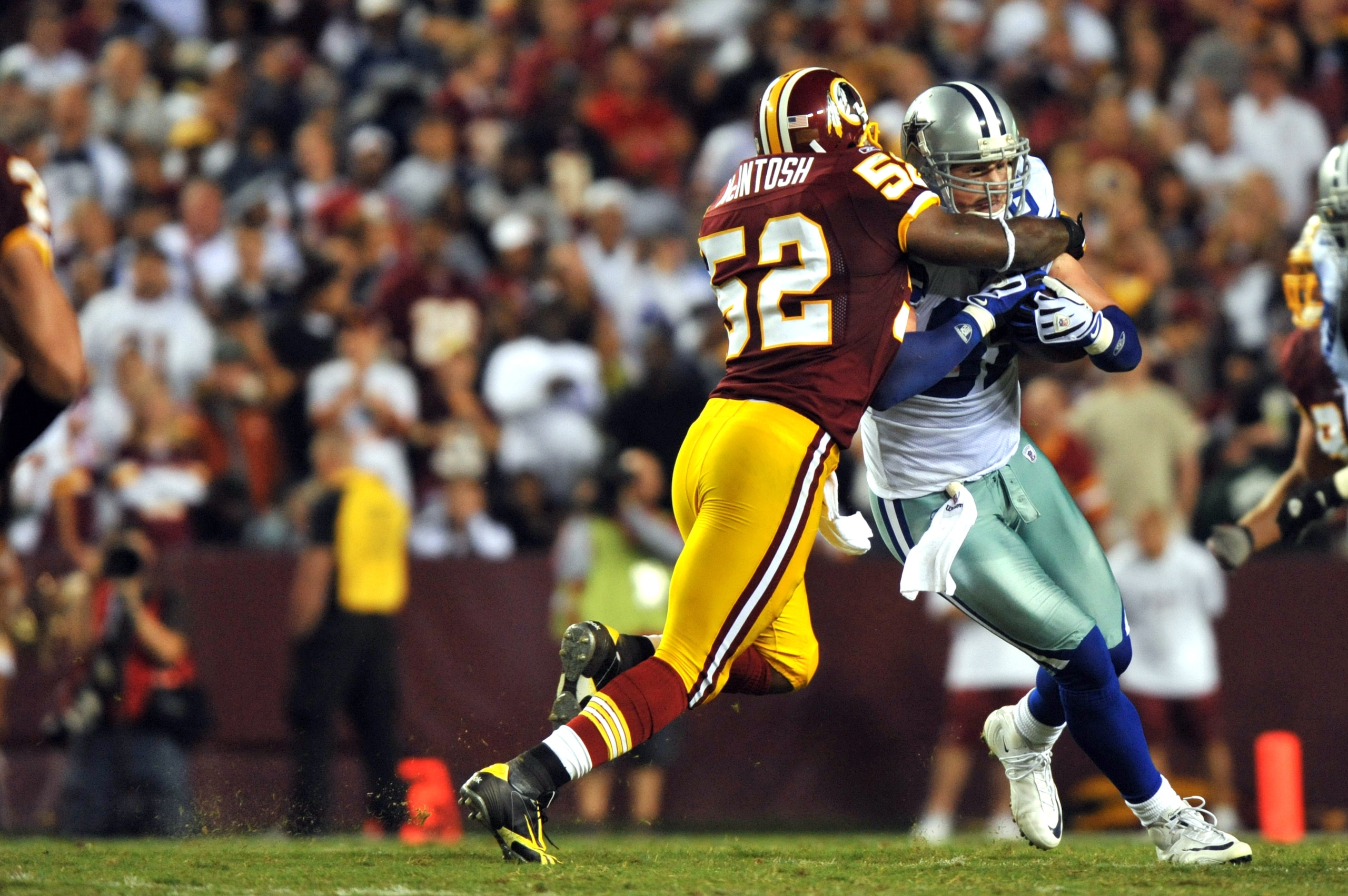LANDOVER - SEPTEMBER 12:  Rocky McIntosh #52 of the Washington Redskins tackles Jason Witten #82 of the Dallas Cowboys during the NFL season opener against the Dallas Cowboys at FedExField on September 12, 2010 in Landover, Maryland. The Redskins defeated