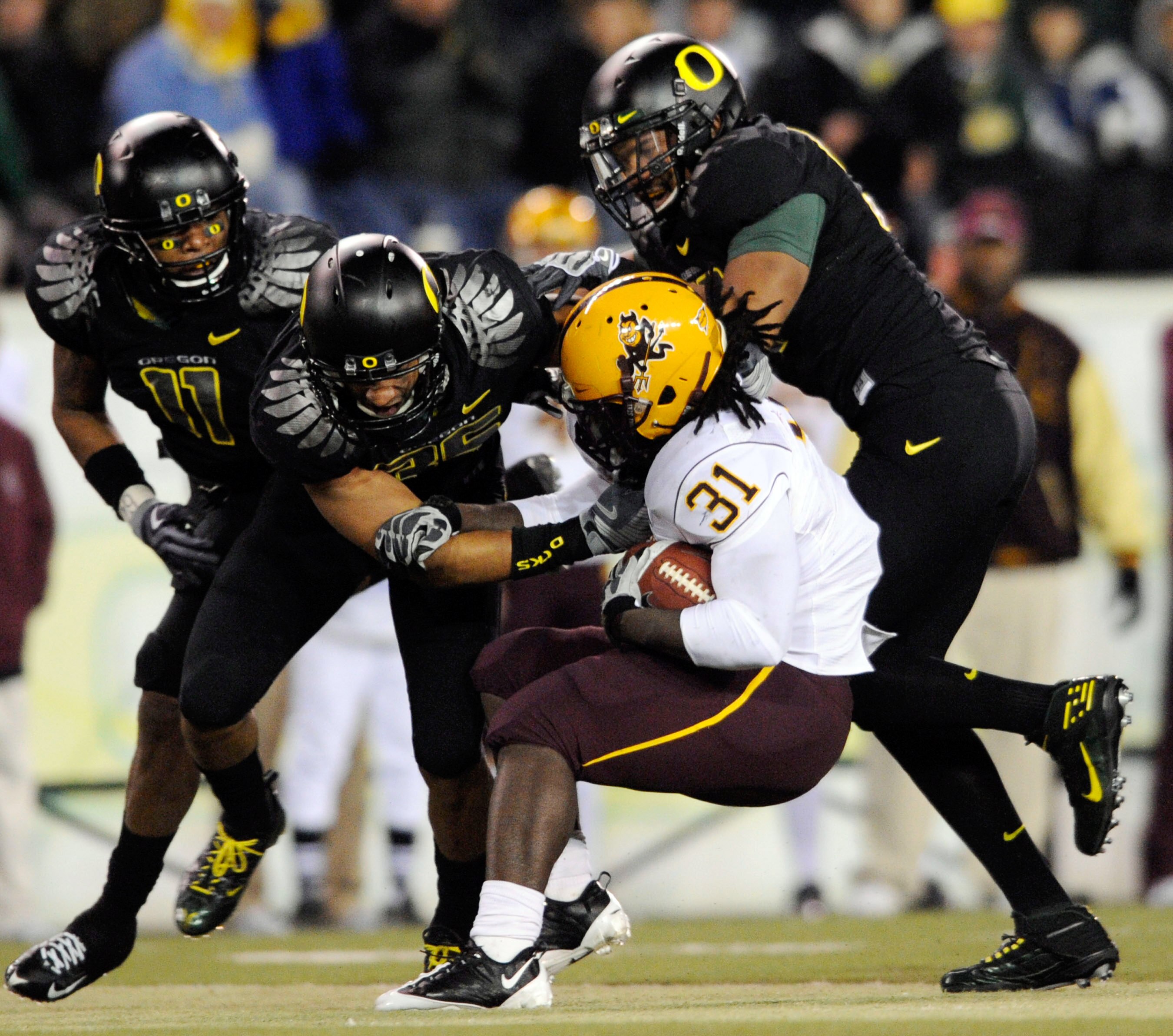 EUGENE,OR - NOVEMBER 14: Linebacker Eddie Pleasant #11, linebacker Spencer Paysinger #35 and linebacker Kenny Rowe #58 of the Oregon Ducks gang up to tackle running back Dimitri Nance #31of the Arizona State Sun Devils in the third quarter of the game at 