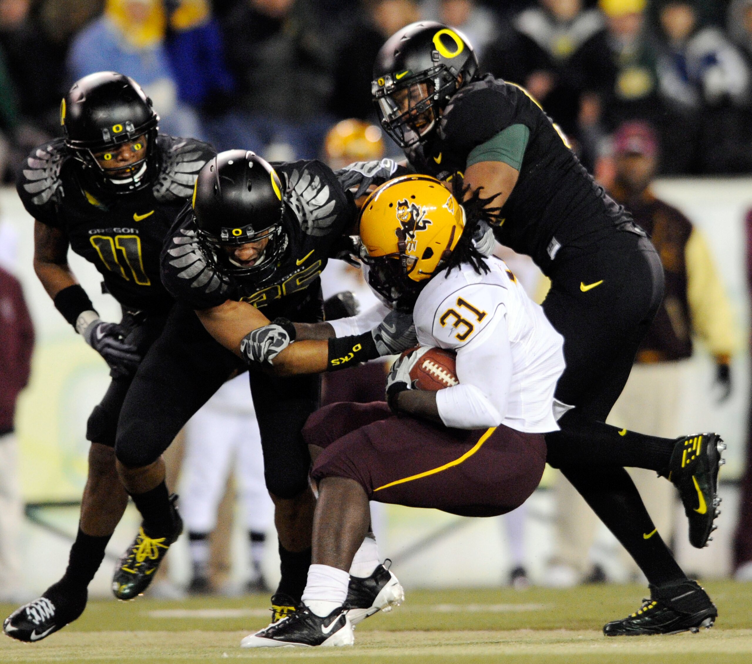 EUGENE,OR - NOVEMBER 14: Linebacker Eddie Pleasant #11, linebacker Spencer Paysinger #35 and linebacker Kenny Rowe #58 of the Oregon Ducks gang up to tackle running back Dimitri Nance #31of the Arizona State Sun Devils in the third quarter of the game at 