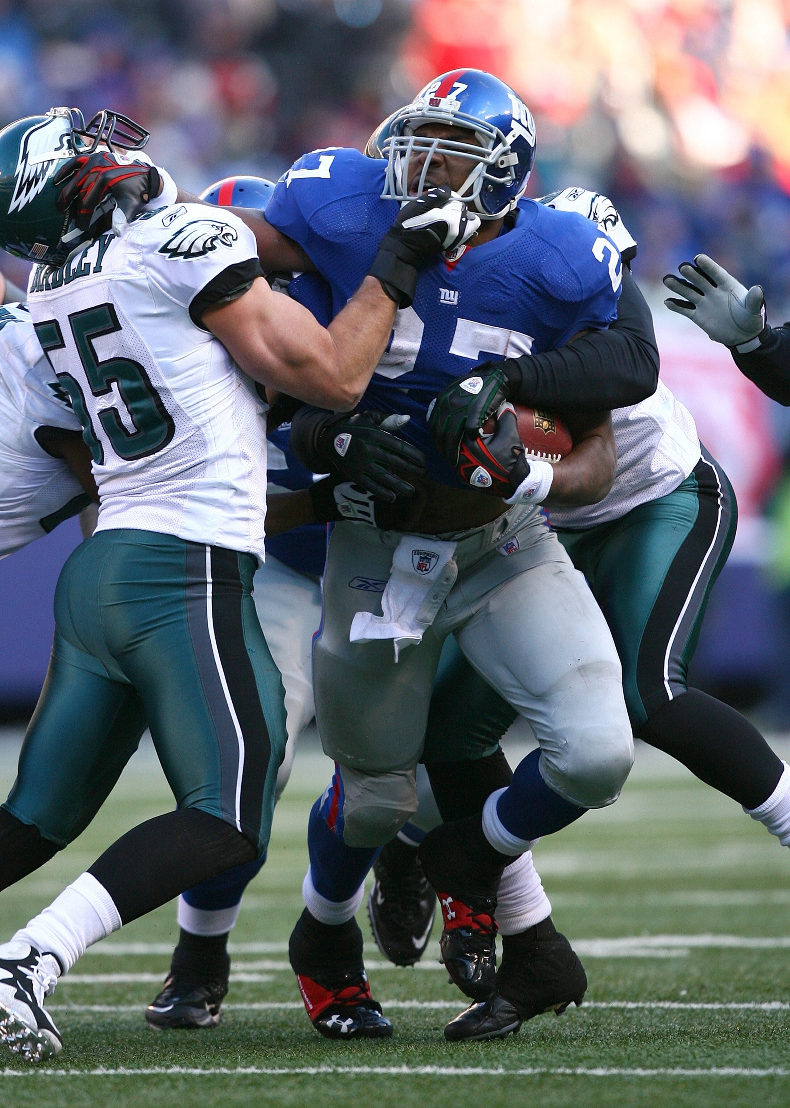 EAST RUTHERFORD, NJ - JANUARY 11:  Brandon Jacobs #27 of the New York Giants stiff arms Stewart Bradley #55 of the Philadelphia Eagles during the NFC Divisional Playoff Game on January 11, 2009 at Giants Stadium in East Rutherford, New Jersey.  The Eagles