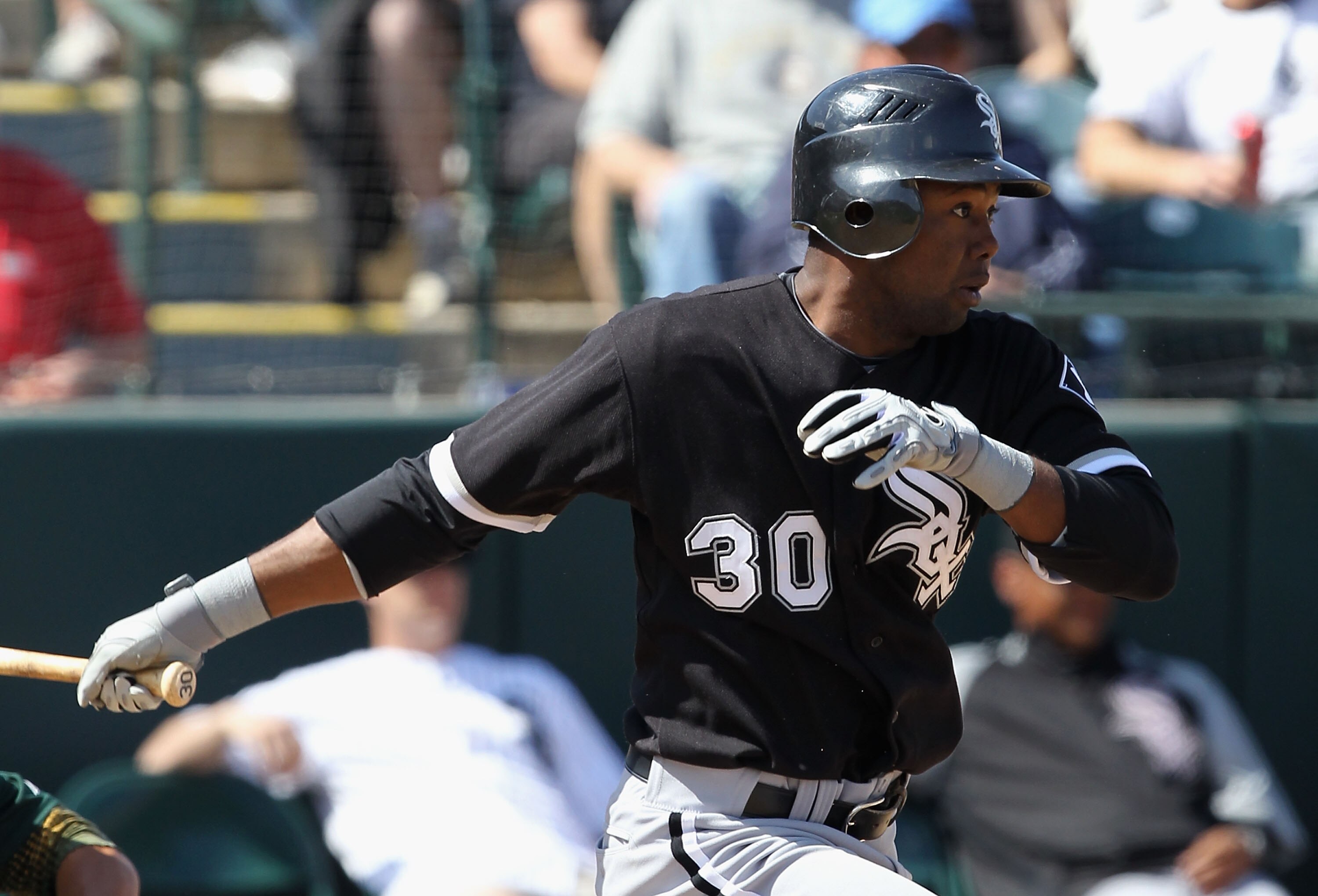 PHOENIX - MARCH 10:  Alejandro De Aza #30 of the Chicago White Sox hits a RBI single against the Oakland Athletics during the third inning of the MLB spring training game at Phoenix Municipal Stadium on March 10, 2010 in Phoenix, Arizona.  (Photo by Chris