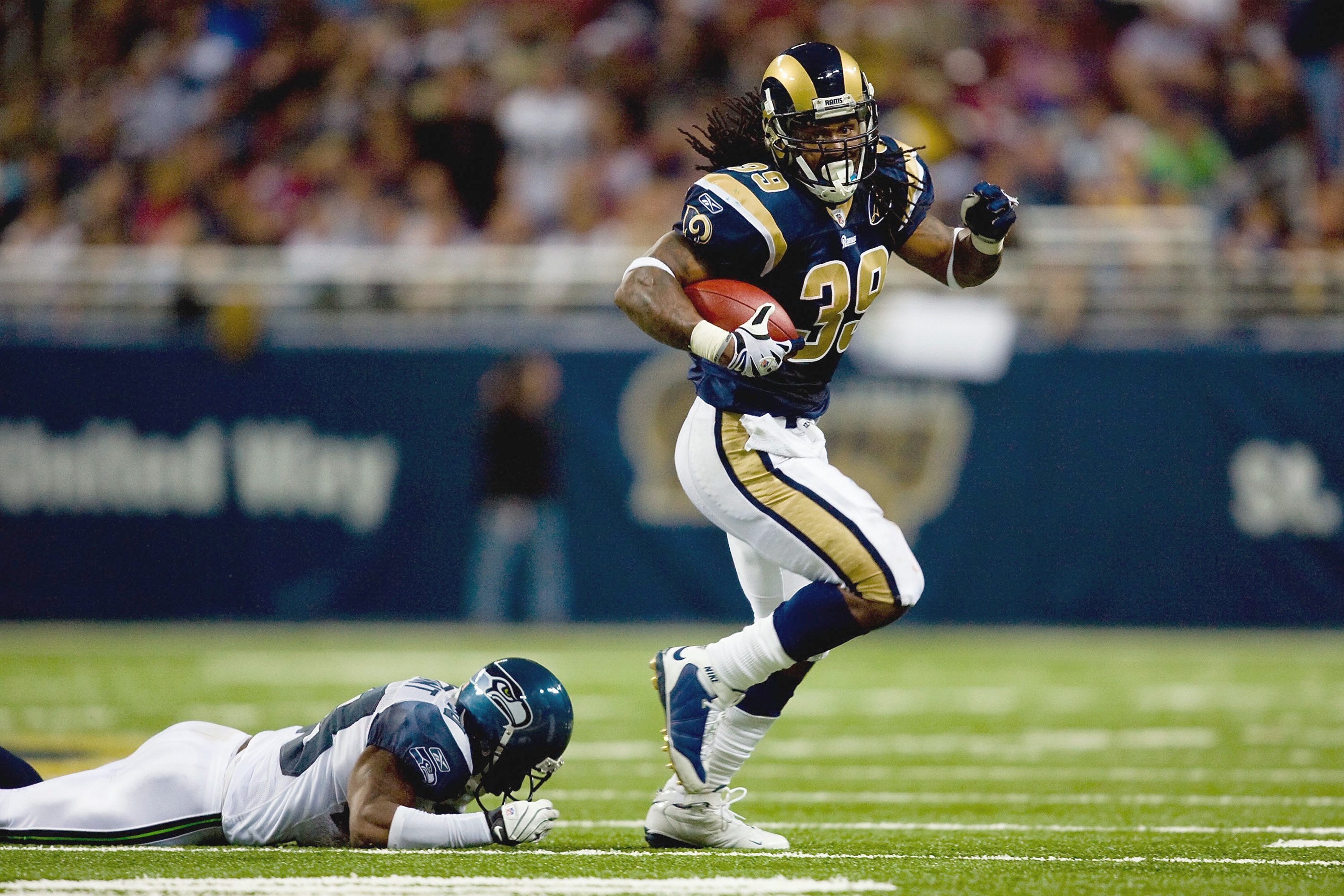ST. LOUIS, MO - DECEMBER 14:  Steven Jackson #39 of the St. Louis Rams carries the ball as he breaks the tackle against Marcus Trufant #23 of the Seattle Seahawks at the Edward Jones Dome on December 14, 2008 in St. Louis, Missouri. (Photo by: Dilip Vishw