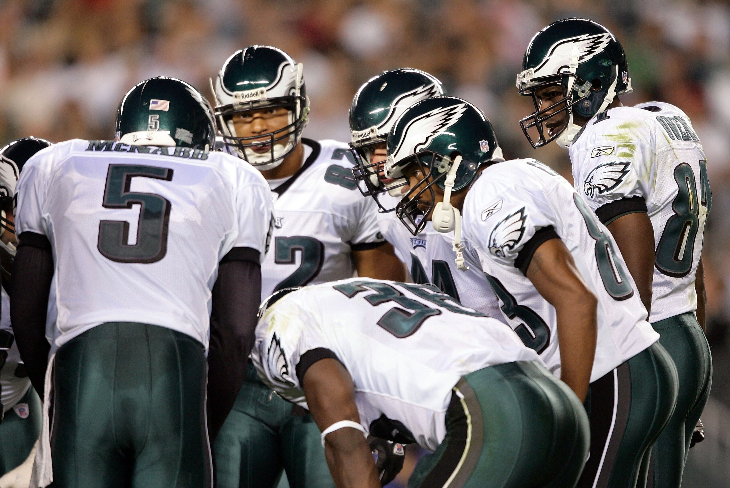 PHILADELPHIA - AUGUST 26:  Wide receiver Terrell Owens #81 (R) of the Philadelphia Eagles listens to quarterback Donovan McNabb #5 in a team huddle during the first half of their preseason game against the Cincinnati Bengals on August 26, 2005 at Lincoln