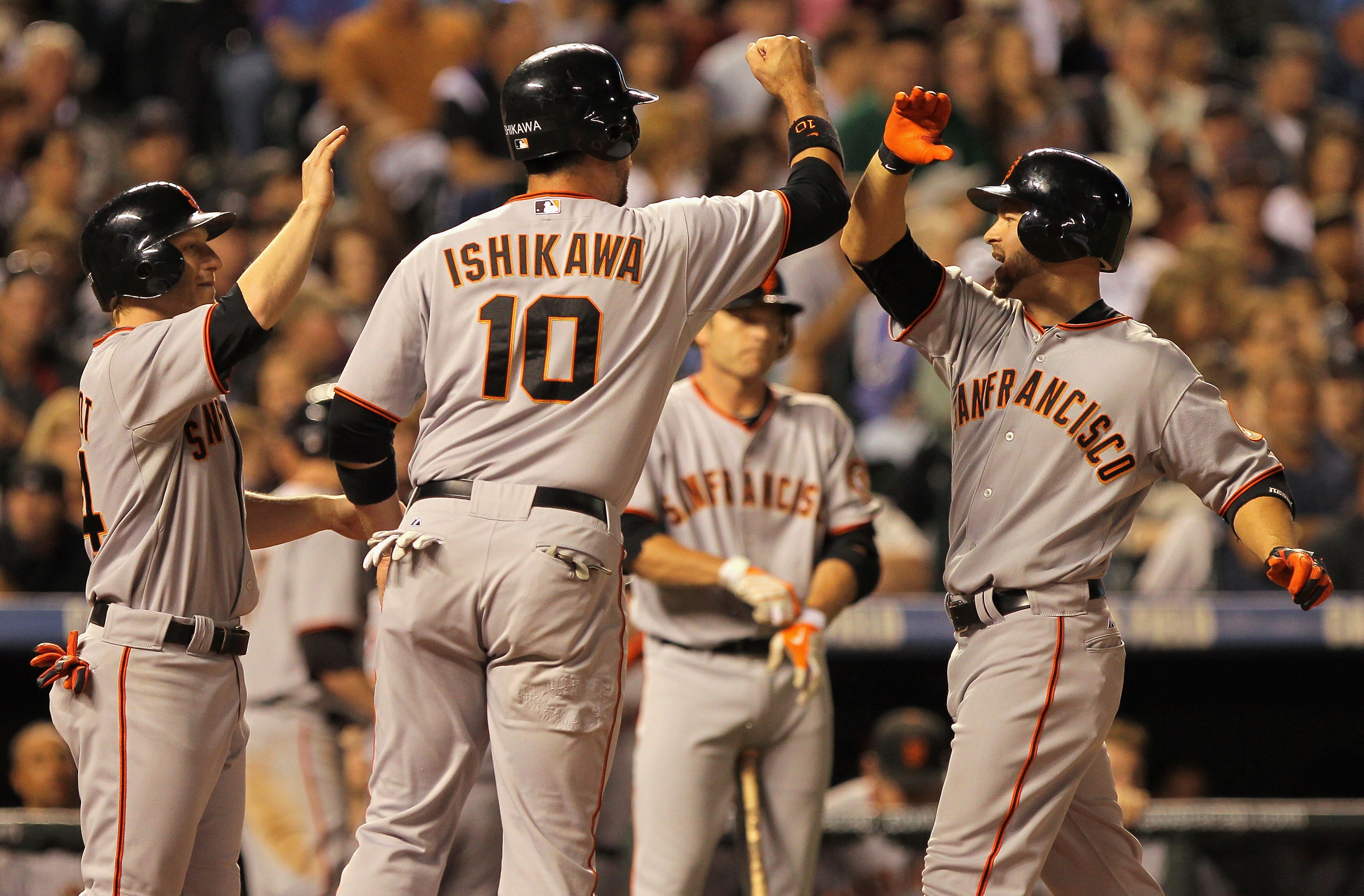 DENVER - SEPTEMBER 25:  Cody Ross #13 (R) of the San Francisco Giants is welcomed home by Travis Ishikawa #10 and Mike Fontenot #14 who scored on his three run home run off of Esmil Rogers of the Colorado Rockies at Coors Field on September 25, 2010 in De