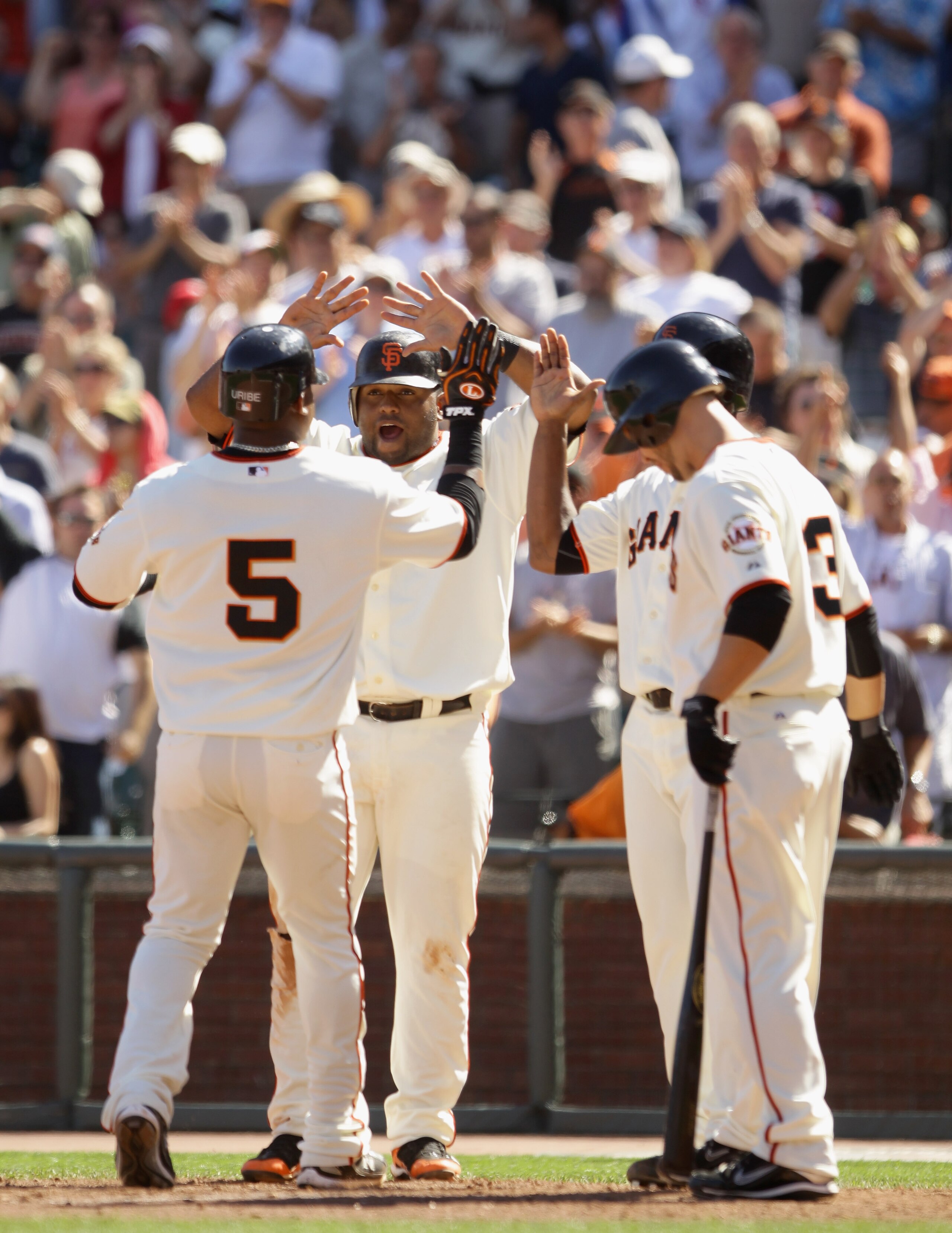 SAN FRANCISCO - AUGUST 25:  Juan Uribe #5 of the San Francisco Giants is congratulated by Pablo Sandoval #48 after he hit a three run home run in the eighth inning of their game against the Cincinnati Reds at AT&T Park on August 25, 2010 in San Francisco,