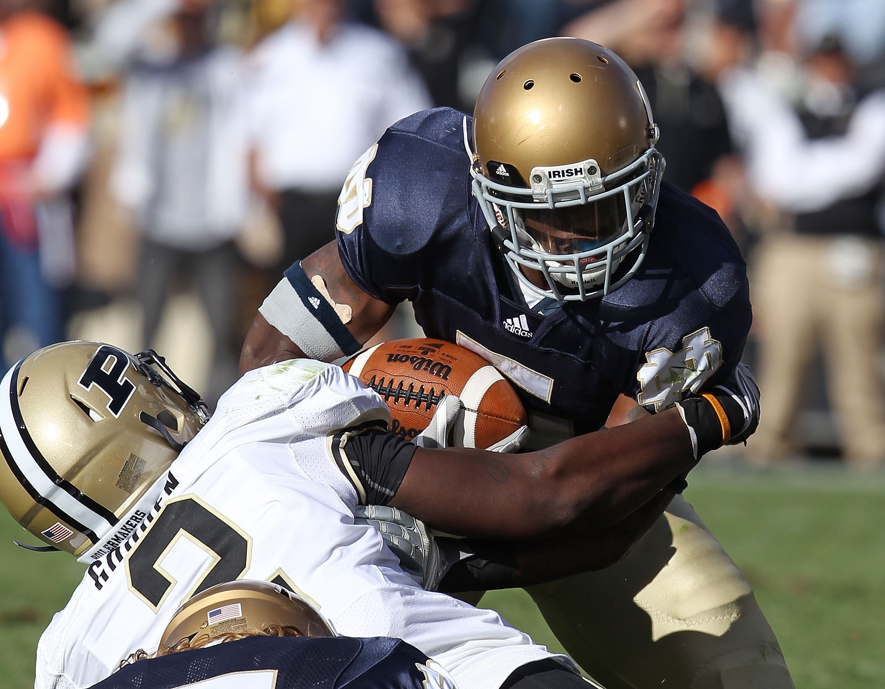 SOUTH BEND, IN - SEPTEMBER 04: Armando Allen Jr. #5 of the Notre Dame Fighting Irish is tackled by Gerald Gooden #2 of the Purdue Boilermakers at Notre Dame Stadium on September 4, 2010 in South Bend, Indiana. Notre Dame defeated Purdue 23-12.  (Photo by