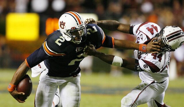 Cam Newton delivers a stiff arm to a South Carolina defender