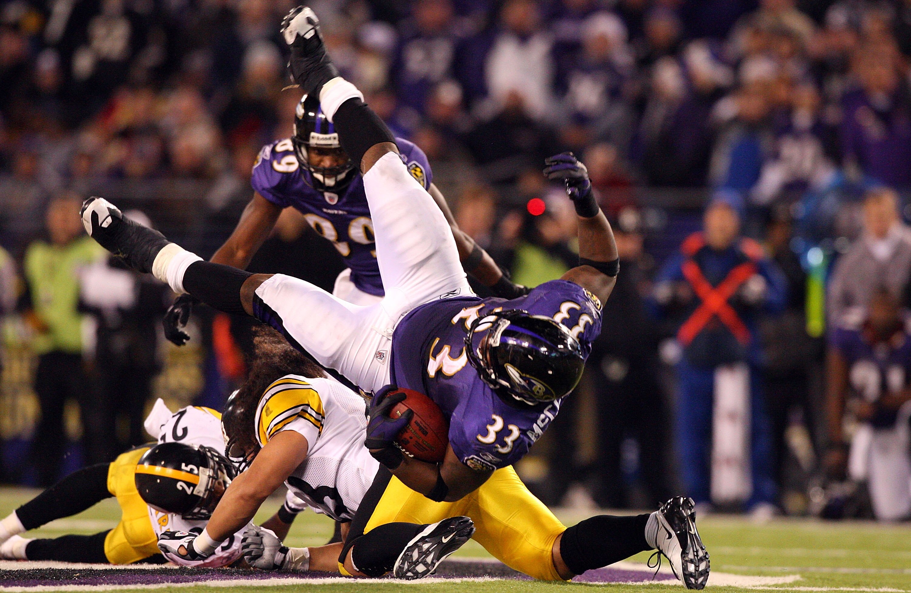 BALTIMORE - DECEMBER 14:  LeRon McClain #33 of the Baltimore Ravens is upended on a run by Troy Polamalu #39 of the Pittsburgh Steelers on December 14, 2008 at M&T Bank Stadium in Baltimore, Maryland. The Steelers defeated the Ravens 13-9.  (Photo by Jim