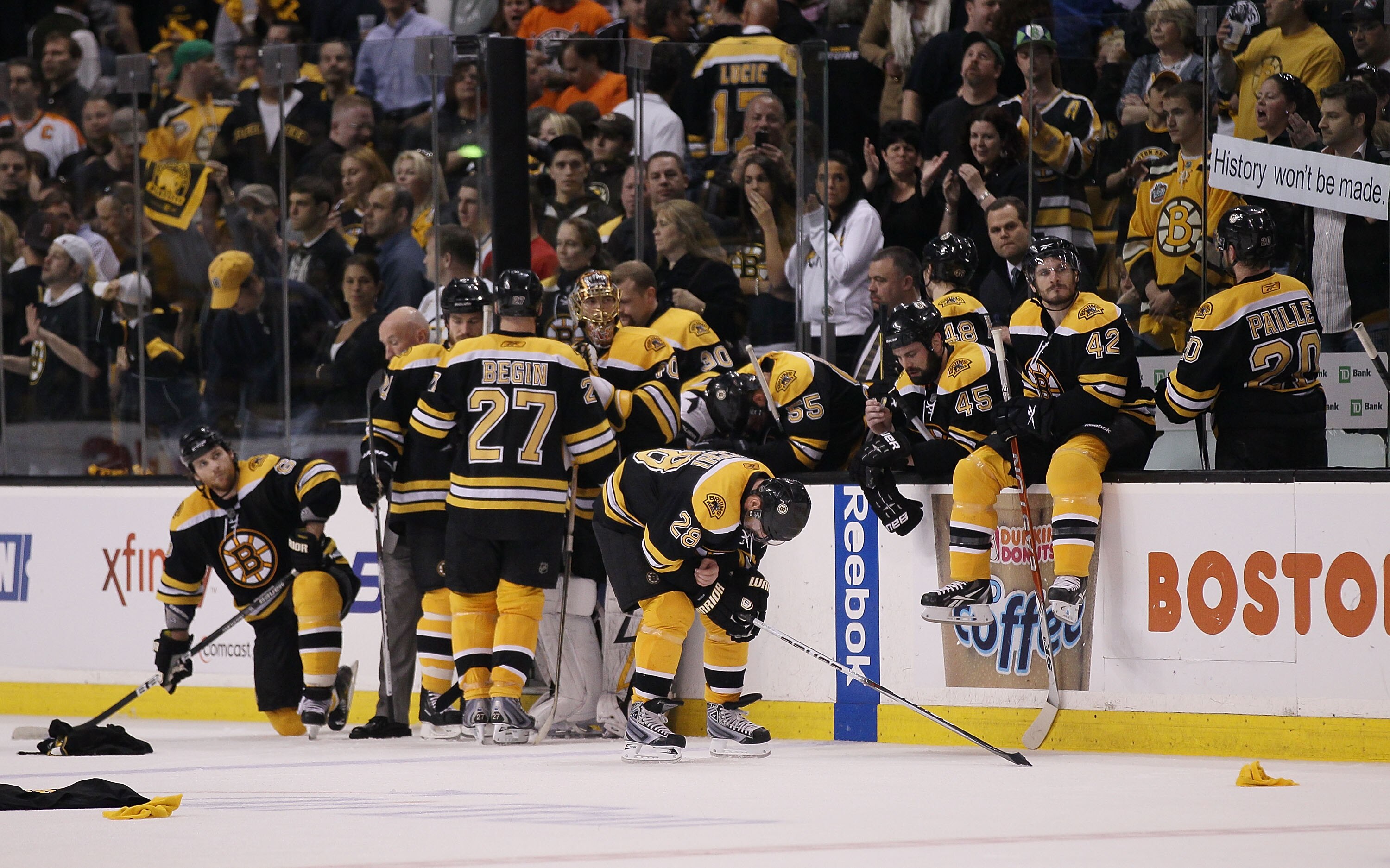BOSTON - MAY 14:  The  Boston Bruins sit near their bench as the Philadelphia Flyers celebrate the win in Game Seven of the Eastern Conference Semifinals during the 2010 NHL Stanley Cup Playoffs at TD Garden on May 14, 2010 in Boston, Massachusetts. The F