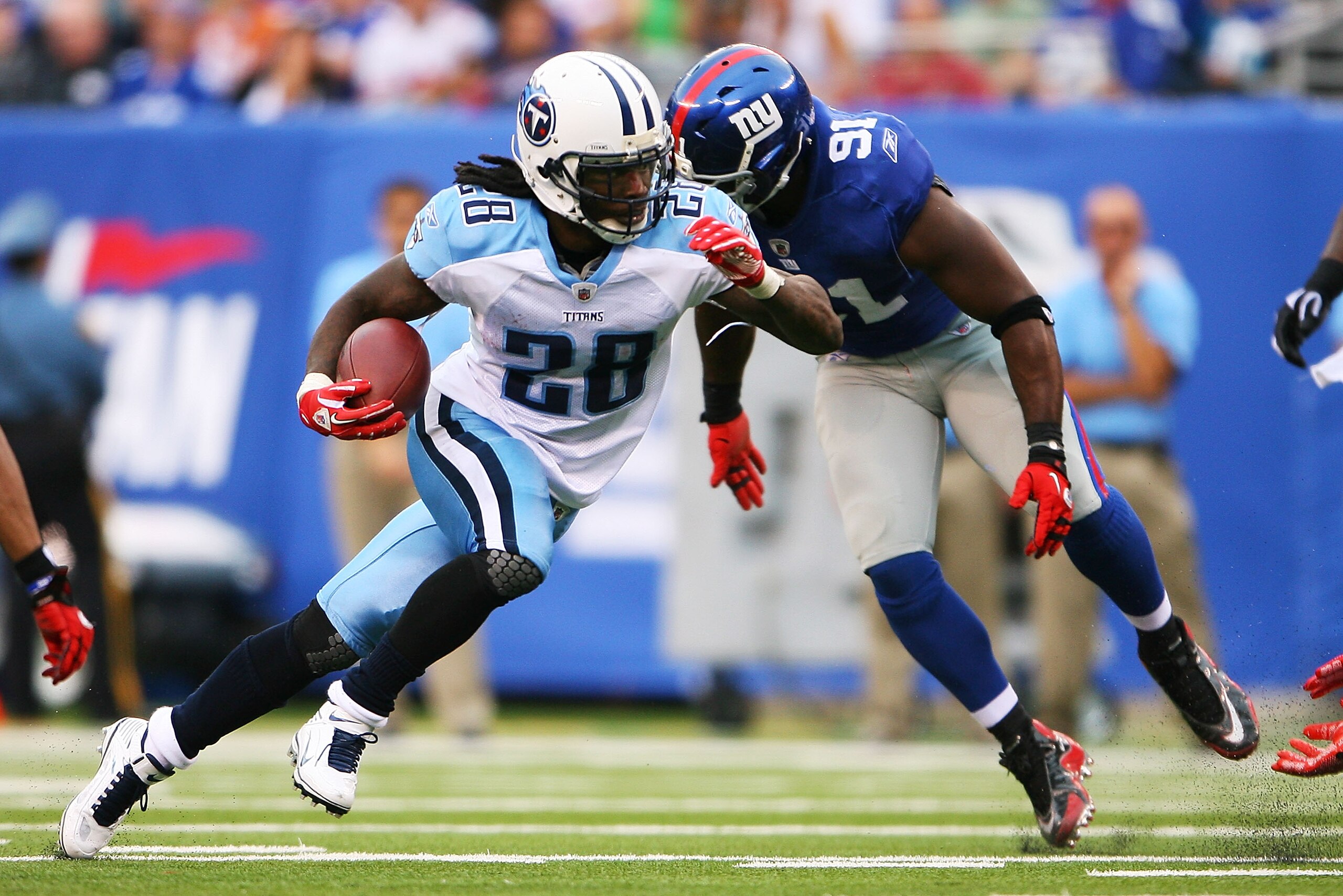 EAST RUTHERFORD, NJ - SEPTEMBER 26: Chris Johnson #28 of the Tennessee Titans runs the ball past Justin Tuck #91 of the New York Giants at New Meadowlands Stadium on September 26, 2010 in East Rutherford, New Jersey. The Titans beat the Giants 29 - 10. (P