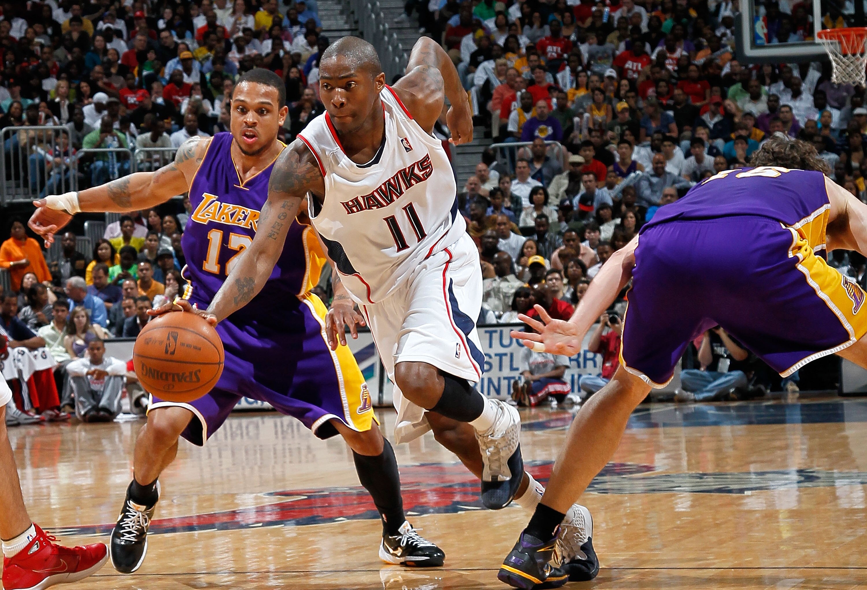 ATLANTA - MARCH 31:  Jamal Crawford #11 of the Atlanta Hawks drives between Shannon Brown #12 and Pau Gasol #16 of the Los Angeles Lakers at Philips Arena on March 31, 2010 in Atlanta, Georgia.  NOTE TO USER: User expressly acknowledges and agrees that, b