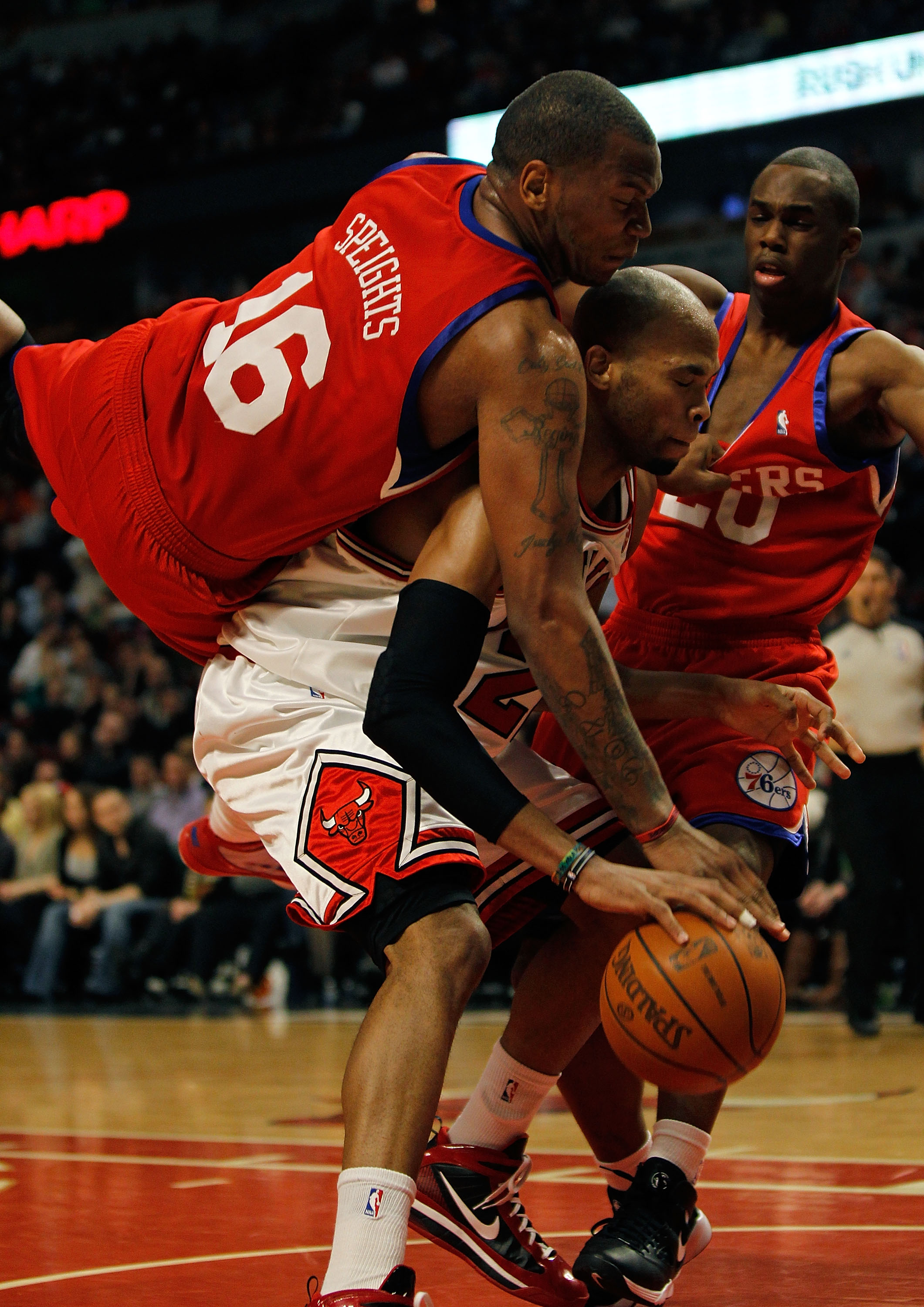 CHICAGO - FEBRUARY 20: Marreese Speights #16 of the Philadelphia 76ers falls over Taj Gibson #22 of the Chicago Bulls while holding the jersey of teammate Jodie Meeks #20 at the United Center on February 20, 2010 in Chicago, Illinois. The Bulls defeated t