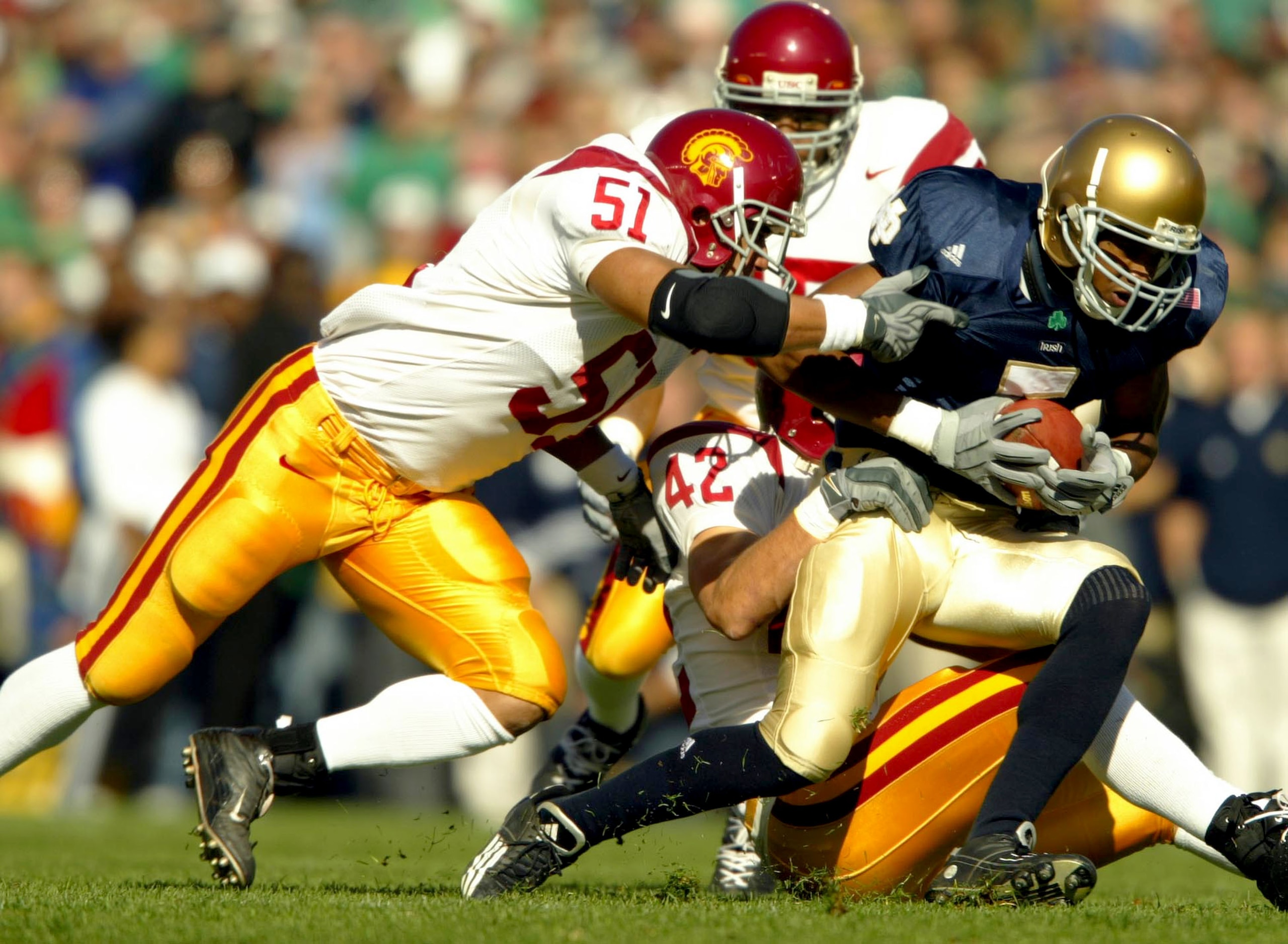 SOUTH BEND, IN - OCTOBER 18:  Rhema McNight #5 of the Notre Dame Fighting Irish is tackled by Melvin Simmons #51 and Dallas Sartz #42 of the USC Trojans on October 18, 2003 at Notre Dame Stadium in South Bend, Indiana.  (Photo by Andy Lyons/Getty Images)