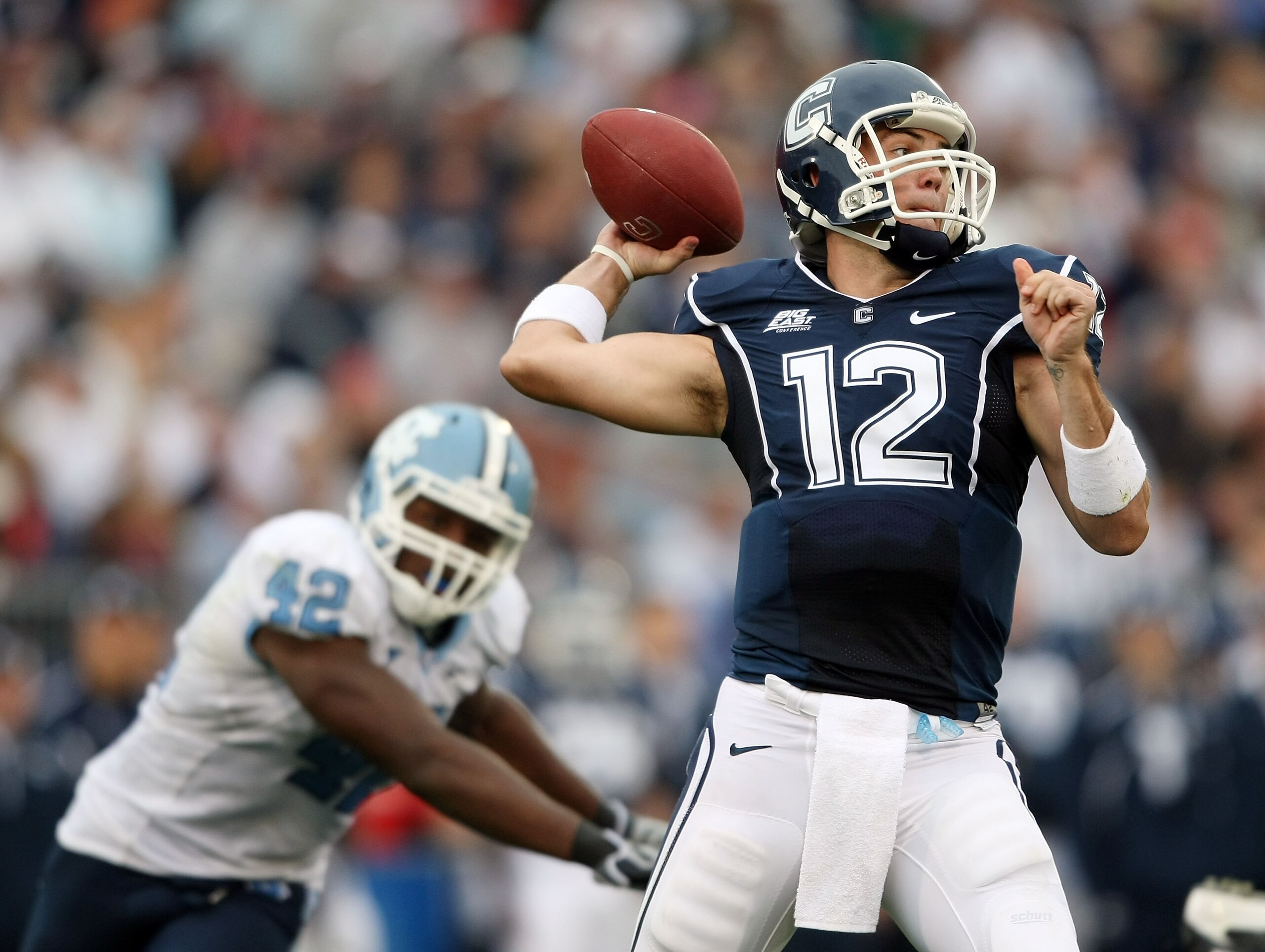 EAST HARTFORD, CT - SEPTEMBER 12: Cody Endres #12 of the Connecticut Huskies passes under pressure from Robert Quinn #42 of the North Carolinia Tar Heels pressures on September 12, 2009 at Rentschler Field in East Hartford, Connecticut. The Tar Heels def EAST HARTFORD, CT - SEPTEMBER 12: Cody Endres #12 of the Connecticut Huskies passes under pressure from Robert Quinn #42 of the North Carolinia Tar Heels pressures on September 12, 2009 at Rentschler Field in East Hartford, Connecticut. The Tar Heels def