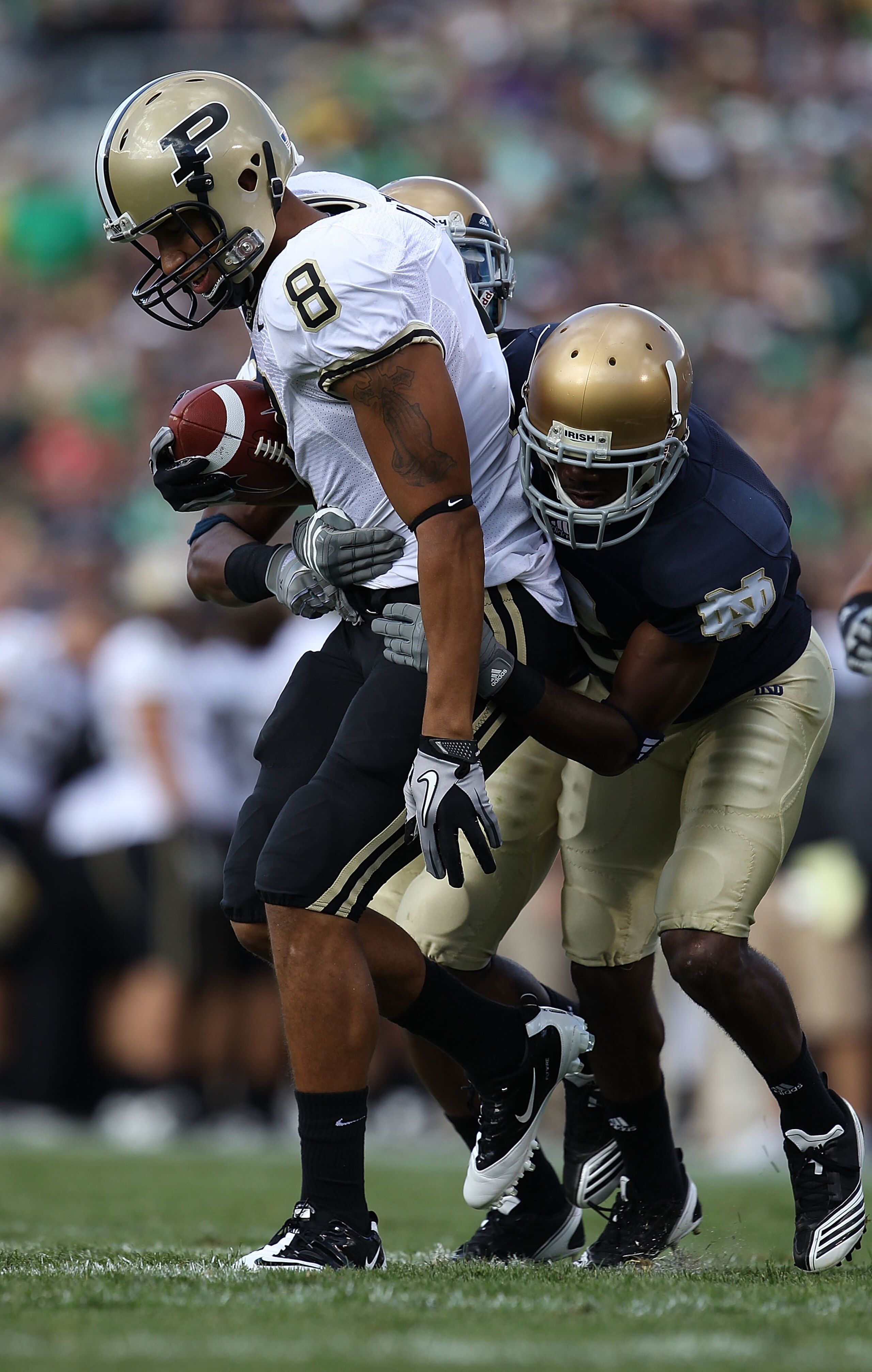 SOUTH BEND, IN - SEPTEMBER 04: Keith Smith #8 of the Purdue Boilermakers is stopped by Darrin Walls #2 (R) and Jamoris Slaughter #26 of the Notre Dame Fighting Irish at Notre Dame Stadium on September 4, 2010 in South Bend, Indiana. Notre Dame defeated Pu