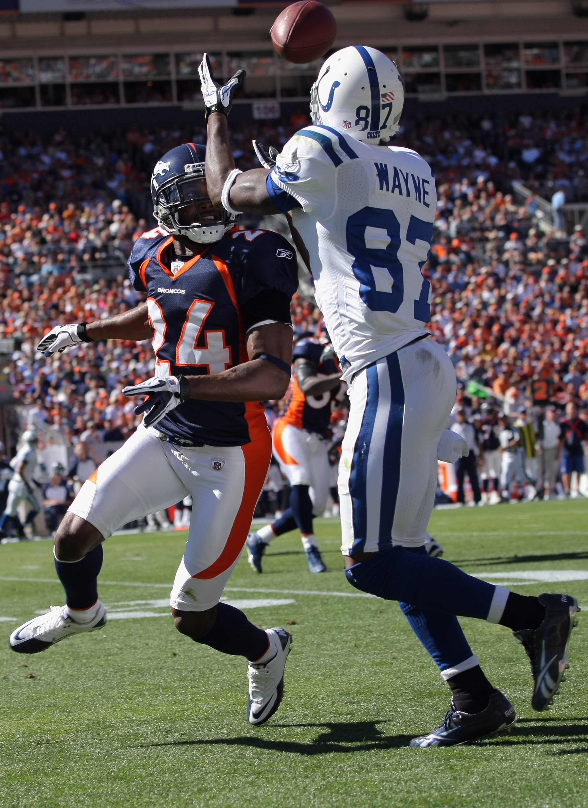 DENVER - SEPTEMBER 26:  Wide receiver Reggie Wayne #87 of the Indianapolis Colts makes a first down reception as Champ Bailey #24 of the Denver Broncos defends at INVESCO Field at Mile High on September 26, 2010 in Denver, Colorado. The Colts defeated the