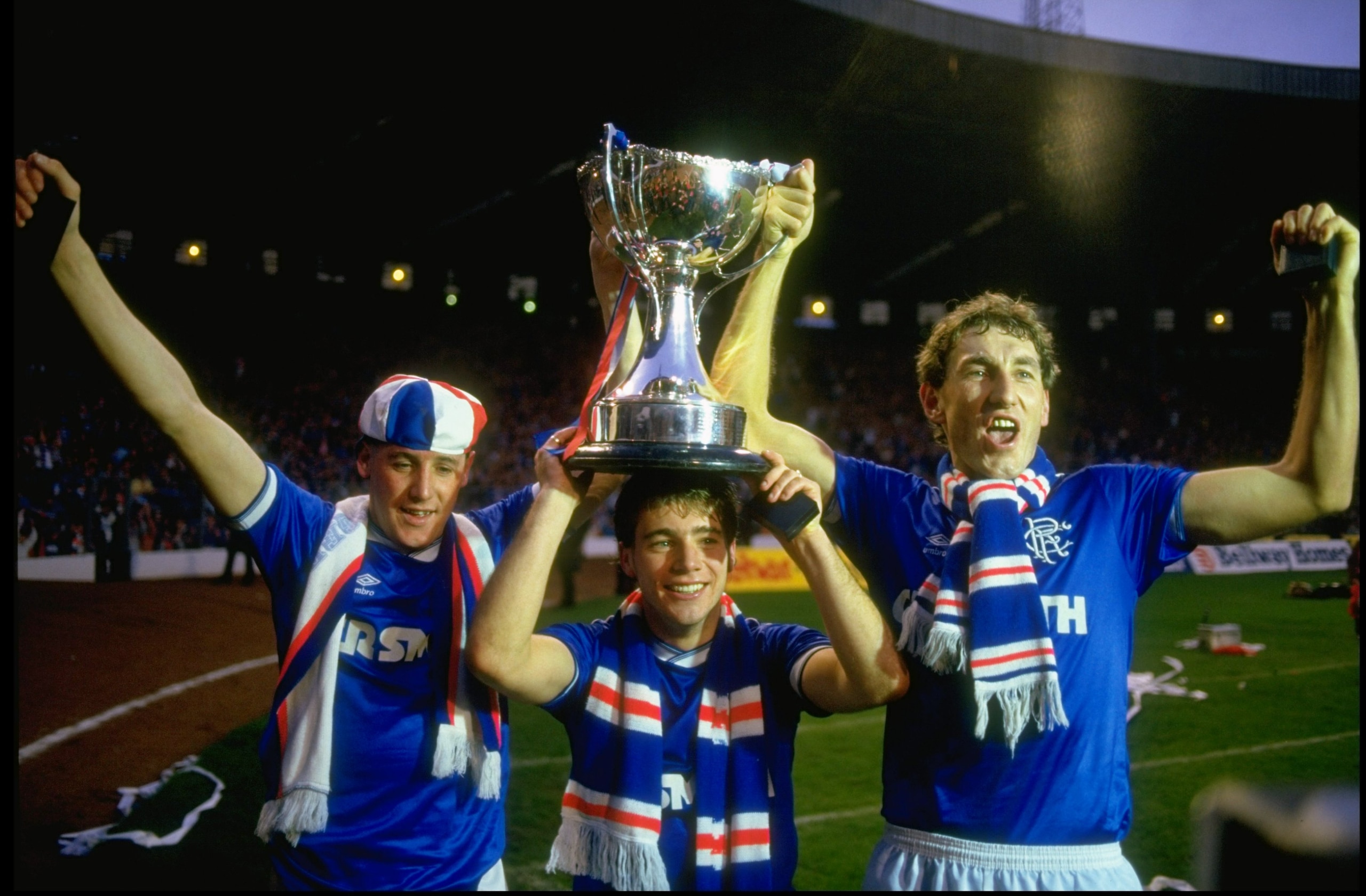 1986:  McNinn (left) Ally McCoist (right) and Terry Butcher (right) all of Rangers celebrate with the Skol Cup trophy after the final against  Celtic in Scotland. Rangers won the match 2-1. \ Mandatory Credit: David  Cannon/Allsport
